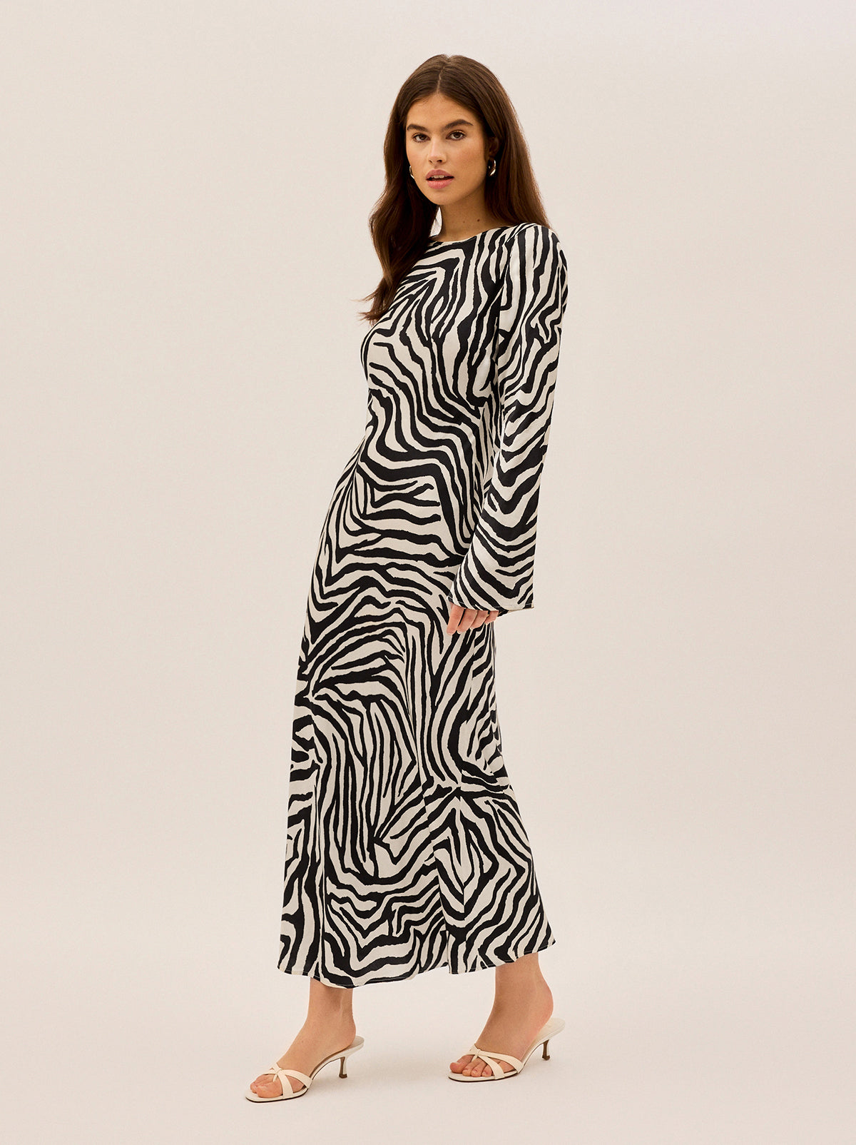 Keira Zebra Print Satin Dress by Kitri Studio. Back by popular demand - now with a new and improved fit! The Keira Dress is a bestseller for a reason, and we’ve made it even better.  Designed to flatter, this bias-cut satin dress drapes effortlessly, skimming the body in all the right places. Slash Neck. Flared sleeves. Slim fit. 55% Viscose 45% Rayon.