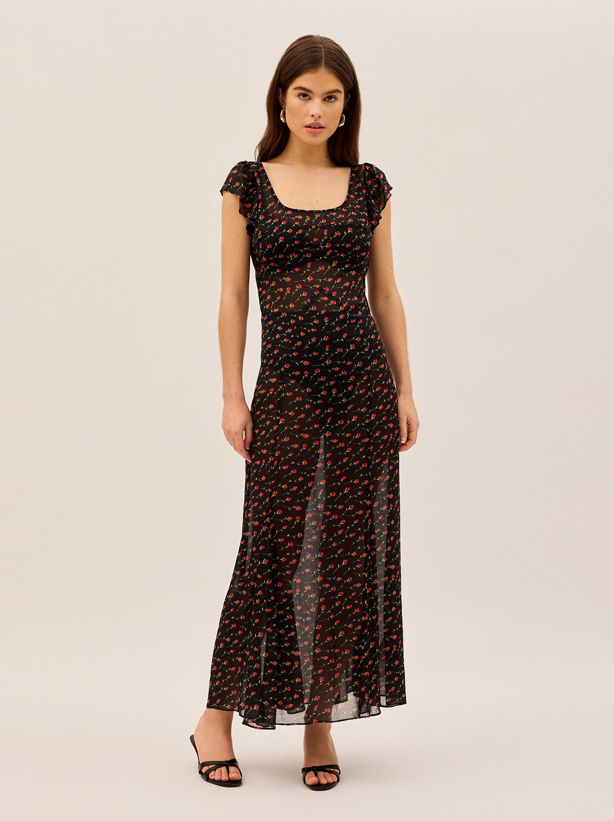 Kaia Black Rose Print Maxi Dress by Kitri Studio. Float through your day in our Kaia dress – a breezy maxi that effortlessly blends romance with modern ease.  The sheer black georgette showcases a delicate rose print that adds subtle movement as you walk. Scoop neck. Cap sleeves. Concealed side-zip. 100%% Viscose .