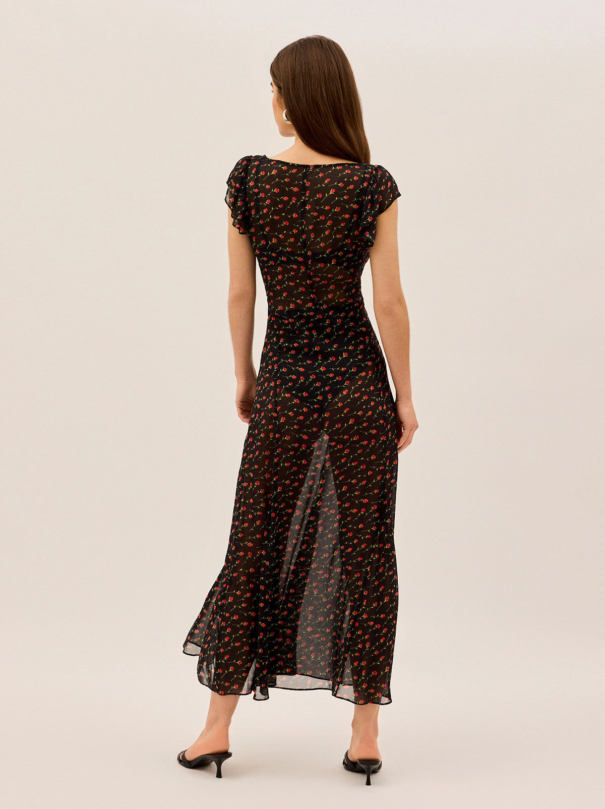 Kaia Black Rose Print Maxi Dress by Kitri Studio. Float through your day in our Kaia dress – a breezy maxi that effortlessly blends romance with modern ease.  The sheer black georgette showcases a delicate rose print that adds subtle movement as you walk. Scoop neck. Cap sleeves. Concealed side-zip. 100%% Viscose .
