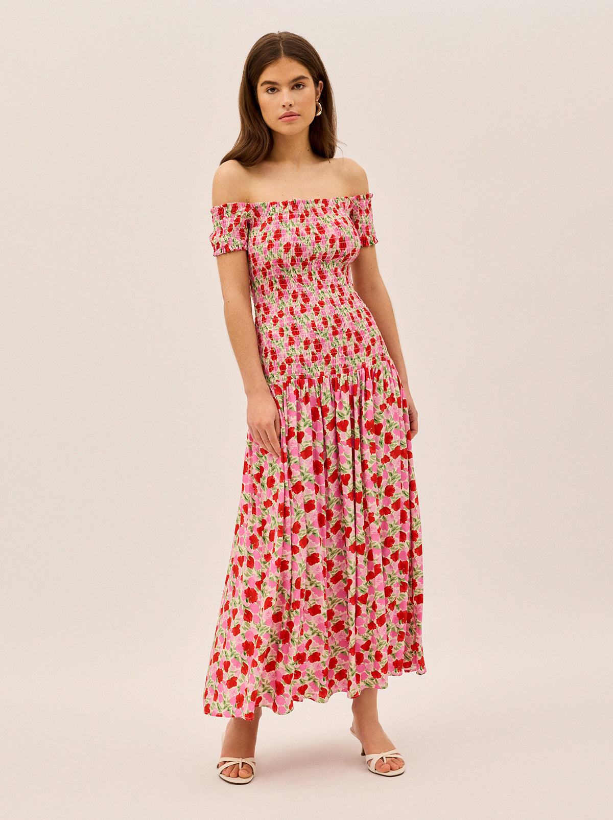 Alma Pink Floral Shirred Maxi Dress by Kitri Studio. Effortlessly romantic, the Alma Dress is your go-to for sun-drenched days and balmy evenings.  Designed with an off-shoulder neckline and a shirred bodice, this maxi dress offers a flattering, comfortable fit that hugs in all the right places. Bardot. Short sleeves. Shirred cuffs. 59%% Lenzing™ Ecovero™ Viscose 41%% Visocse Lining; 100%% Recycled Polyester.