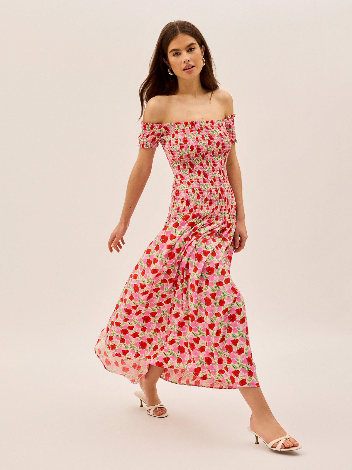 Alma Pink Floral Shirred Maxi Dress by Kitri Studio. Effortlessly romantic, the Alma Dress is your go-to for sun-drenched days and balmy evenings.  Designed with an off-shoulder neckline and a shirred bodice, this maxi dress offers a flattering, comfortable fit that hugs in all the right places. Bardot. Short sleeves. Shirred cuffs. 59%% Lenzing™ Ecovero™ Viscose 41%% Visocse Lining; 100%% Recycled Polyester.