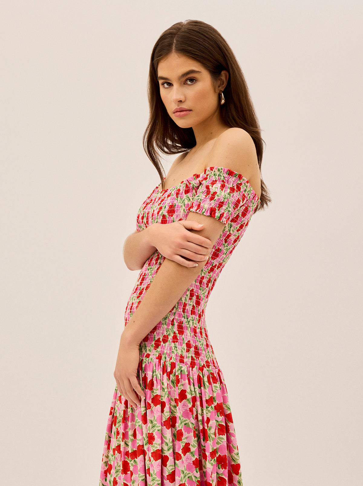 Alma Pink Floral Shirred Maxi Dress by Kitri Studio. Effortlessly romantic, the Alma Dress is your go-to for sun-drenched days and balmy evenings.  Designed with an off-shoulder neckline and a shirred bodice, this maxi dress offers a flattering, comfortable fit that hugs in all the right places. Bardot. Short sleeves. Shirred cuffs. 59%% Lenzing™ Ecovero™ Viscose 41%% Visocse Lining; 100%% Recycled Polyester.