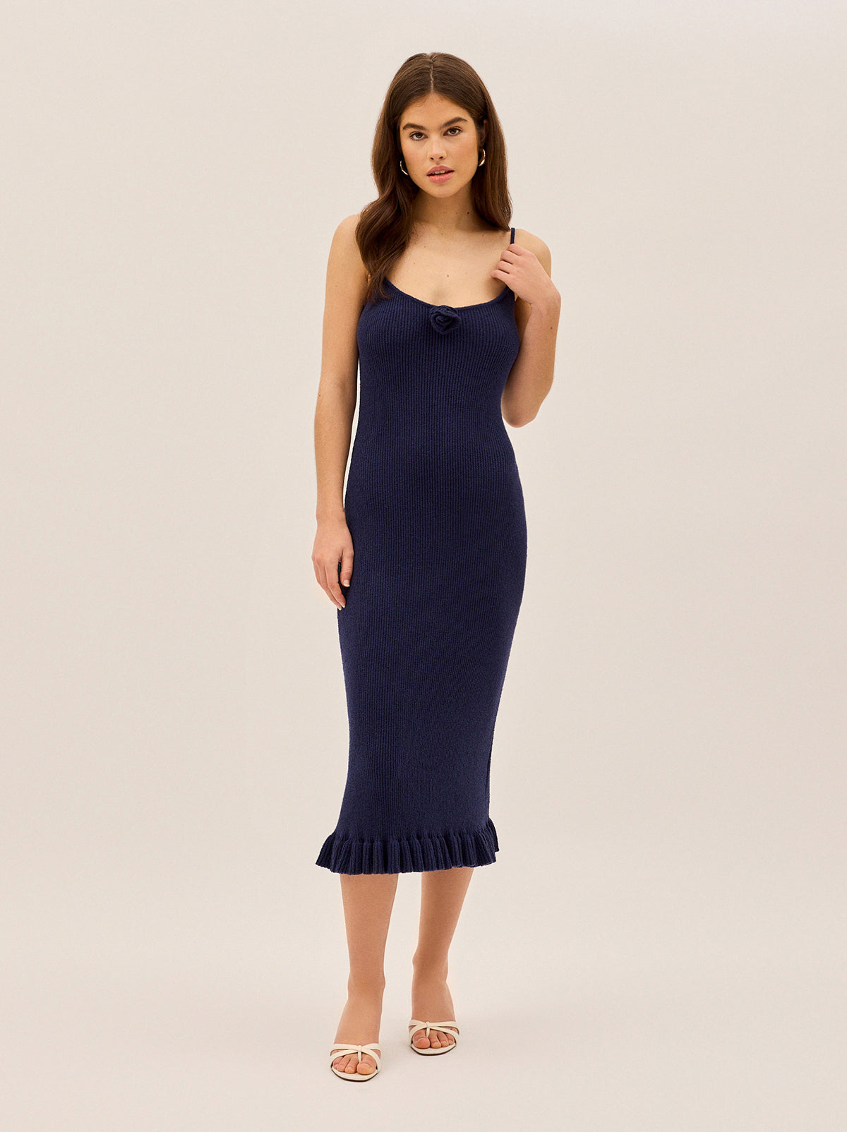Betty Navy Knit Dress by Kitri Studio. A timeless silhouette with a playful twist, the Betty Dress is all about understated sophistication with a feminine edge.  Crafted from a lightweight crepe ribbed knit, this midi dress is fitted throughout for a flattering, sculpted look. Straight neckline. Spaghetti straps. Fitted. 65% Cotton, 35% Nylon.