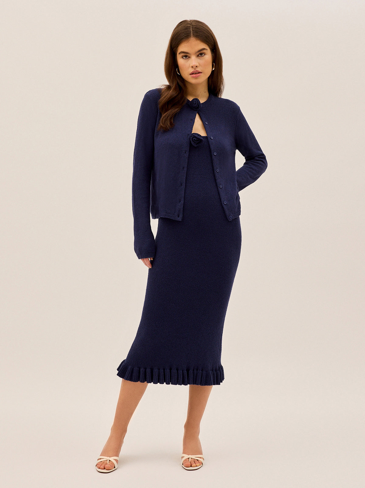 Betty Navy Knit Dress by Kitri Studio. A timeless silhouette with a playful twist, the Betty Dress is all about understated sophistication with a feminine edge.  Crafted from a lightweight crepe ribbed knit, this midi dress is fitted throughout for a flattering, sculpted look. Straight neckline. Spaghetti straps. Fitted. 65% Cotton, 35% Nylon.