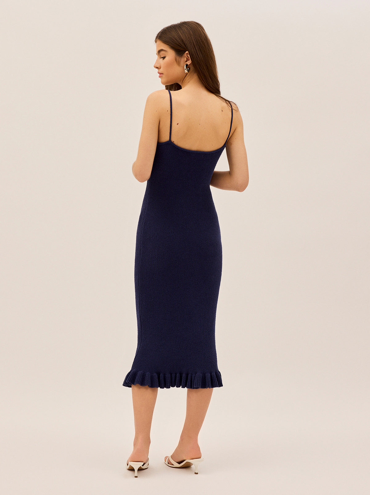 Betty Navy Knit Dress by Kitri Studio. A timeless silhouette with a playful twist, the Betty Dress is all about understated sophistication with a feminine edge.  Crafted from a lightweight crepe ribbed knit, this midi dress is fitted throughout for a flattering, sculpted look. Straight neckline. Spaghetti straps. Fitted. 65% Cotton, 35% Nylon.