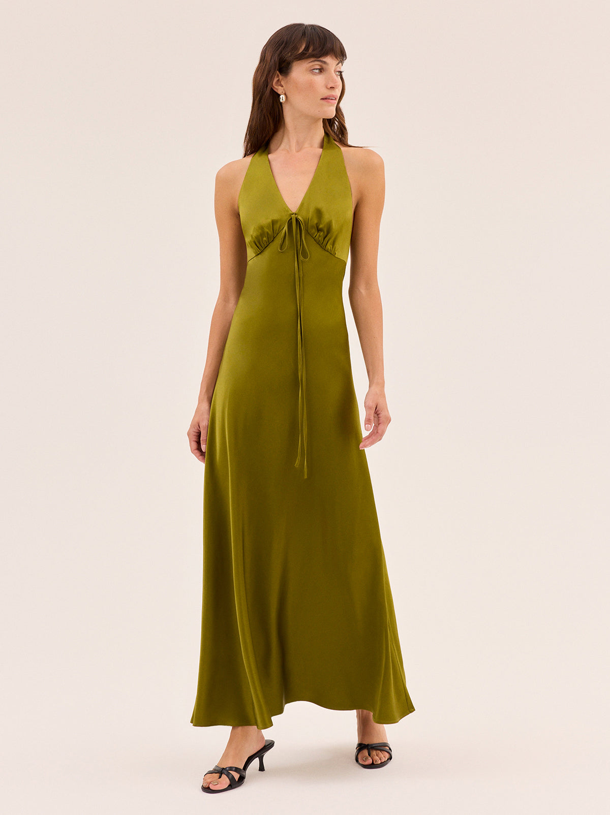 Amalia Olive Satin Halterneck Dress by Kitri Studio. Timeless, feminine and cut to flatter, Amalia is the dress everyone will ask about.  Designed in flattering olive satin fabrication, this halterneck maxi features a deep V neckline with delicate tie detail and a softly flared silhouette. Halter neckline. Back-zip. A-line skirt. 97% Viscose, 3% Elastane Satin .