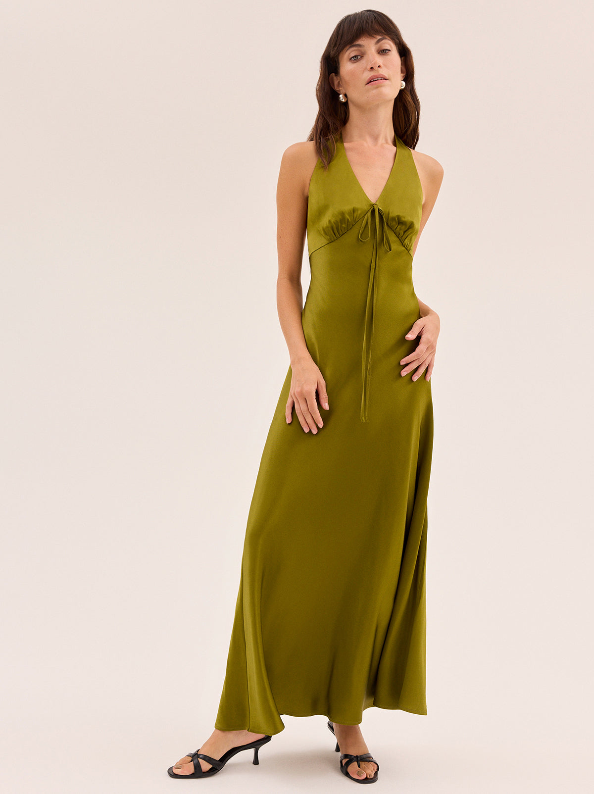 Amalia Olive Satin Halterneck Dress by Kitri Studio. Timeless, feminine and cut to flatter, Amalia is the dress everyone will ask about.  Designed in flattering olive satin fabrication, this halterneck maxi features a deep V neckline with delicate tie detail and a softly flared silhouette. Halter neckline. Back-zip. A-line skirt. 97% Viscose, 3% Elastane Satin .