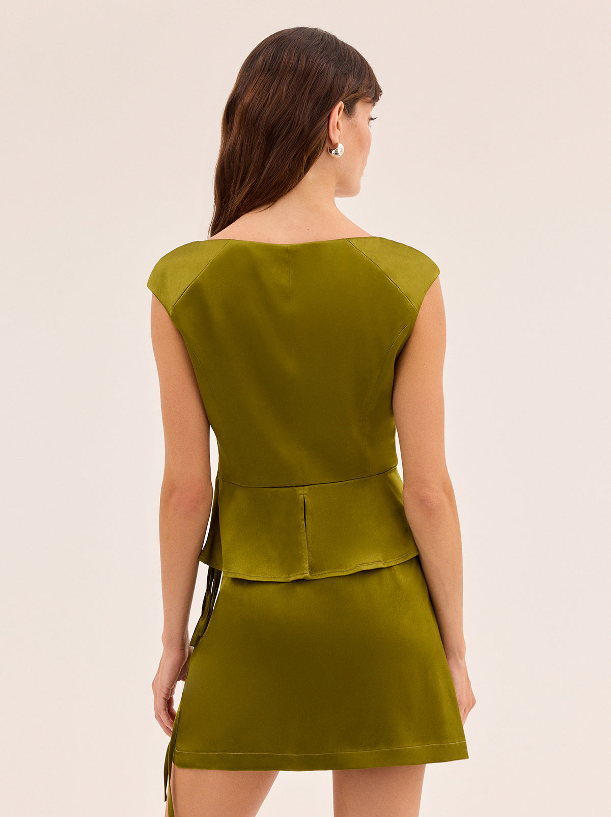 Amina Olive Satin Top by Kitri Studio. Amina Olive Satin Top is cut in a flattering peplum silhouette that gently skims the body while adding a touch of femininity.  Crafted from lustrous olive green satin, it’s finished with a wide scoop neckline that feels both modern and timeless. Scoop neck. Concealed side-zip. . 97% Viscose, 3% Elastane Satin .