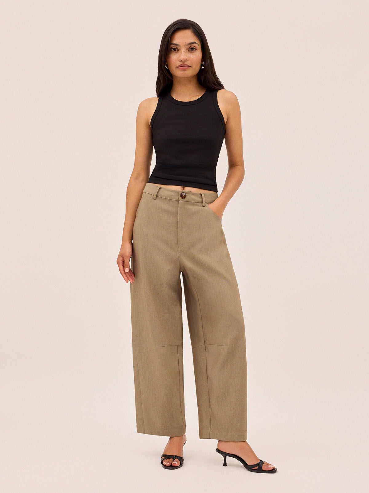 Andie Taupe Barrel Leg Tailored Trousers by Kitri Studio. The Andie trousers put a modern spin on classic tailoring.  Cut in a barrel leg shape with a mid-rise fit, they’re crafted in a versatile taupe tone that pairs effortlessly with everything. Button and zip fly front. High waisted. Relaxed Fit. 74% Polyester, 20% Rayon, 6% Elastane.