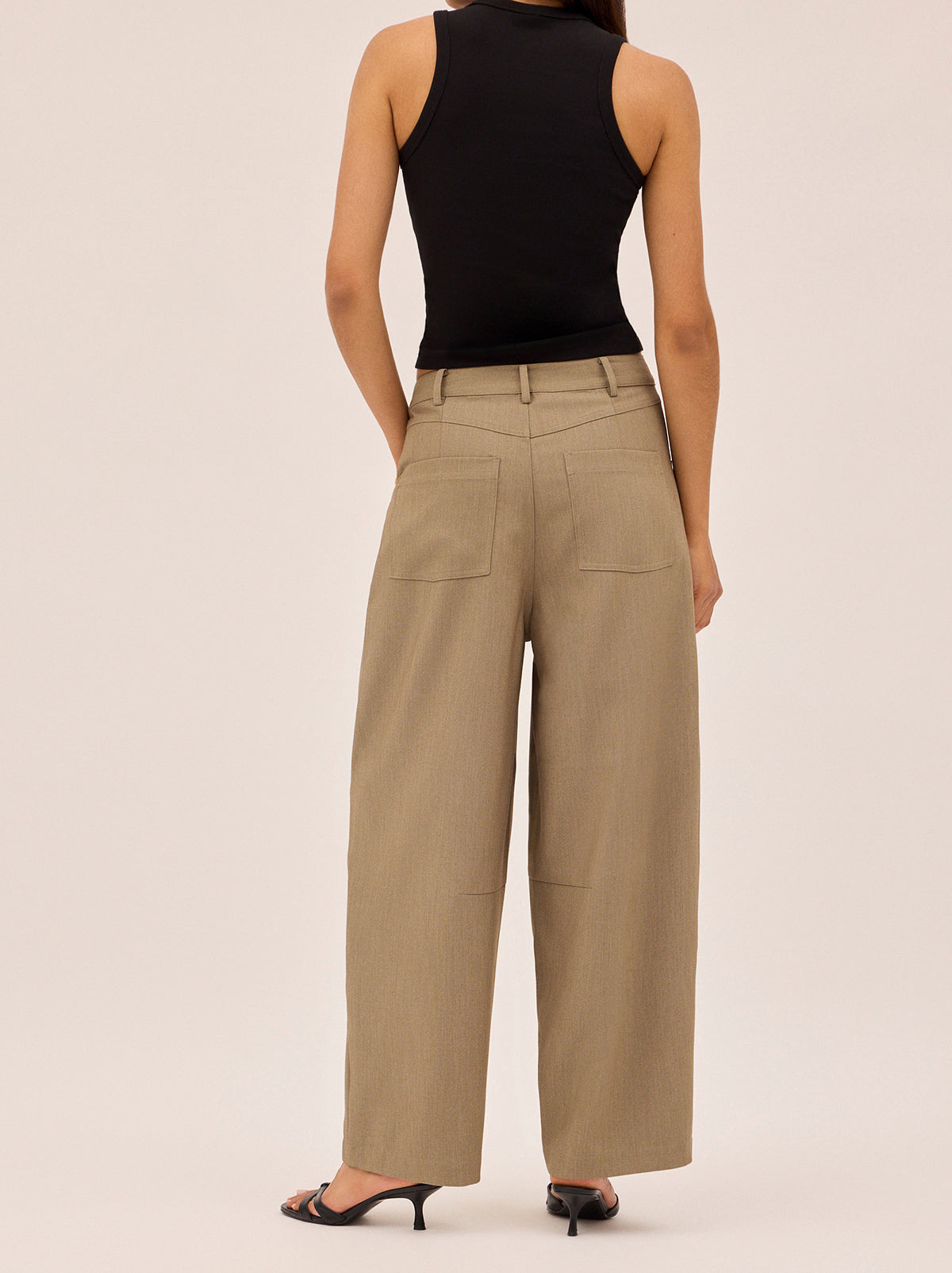 Andie Taupe Barrel Leg Tailored Trousers by Kitri Studio. The Andie trousers put a modern spin on classic tailoring.  Cut in a barrel leg shape with a mid-rise fit, they’re crafted in a versatile taupe tone that pairs effortlessly with everything. Button and zip fly front. High waisted. Relaxed Fit. 74% Polyester, 20% Rayon, 6% Elastane.