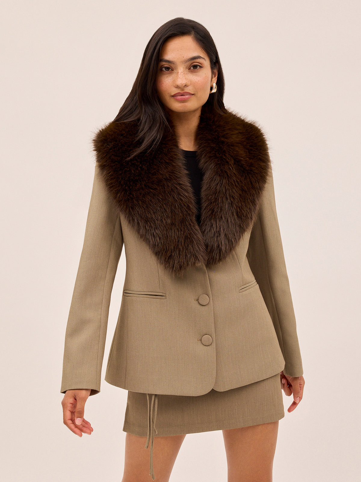 Anthia Tailored Blazer by Kitri Studio. The Anthia blazer brings statement-making polish to your wardrobe.  Expertly tailored in a versatile taupe hue, it’s cinched at the waist for a flattering fit and finished with a detachable faux-fur collar in rich chocolate brown for a touch of vintage glamour. Long sleeves. Button front. Fully lined. Main: 74% Polyester, 20% Rayon, 6% Elastane Faux Fur: 100% Polyester.