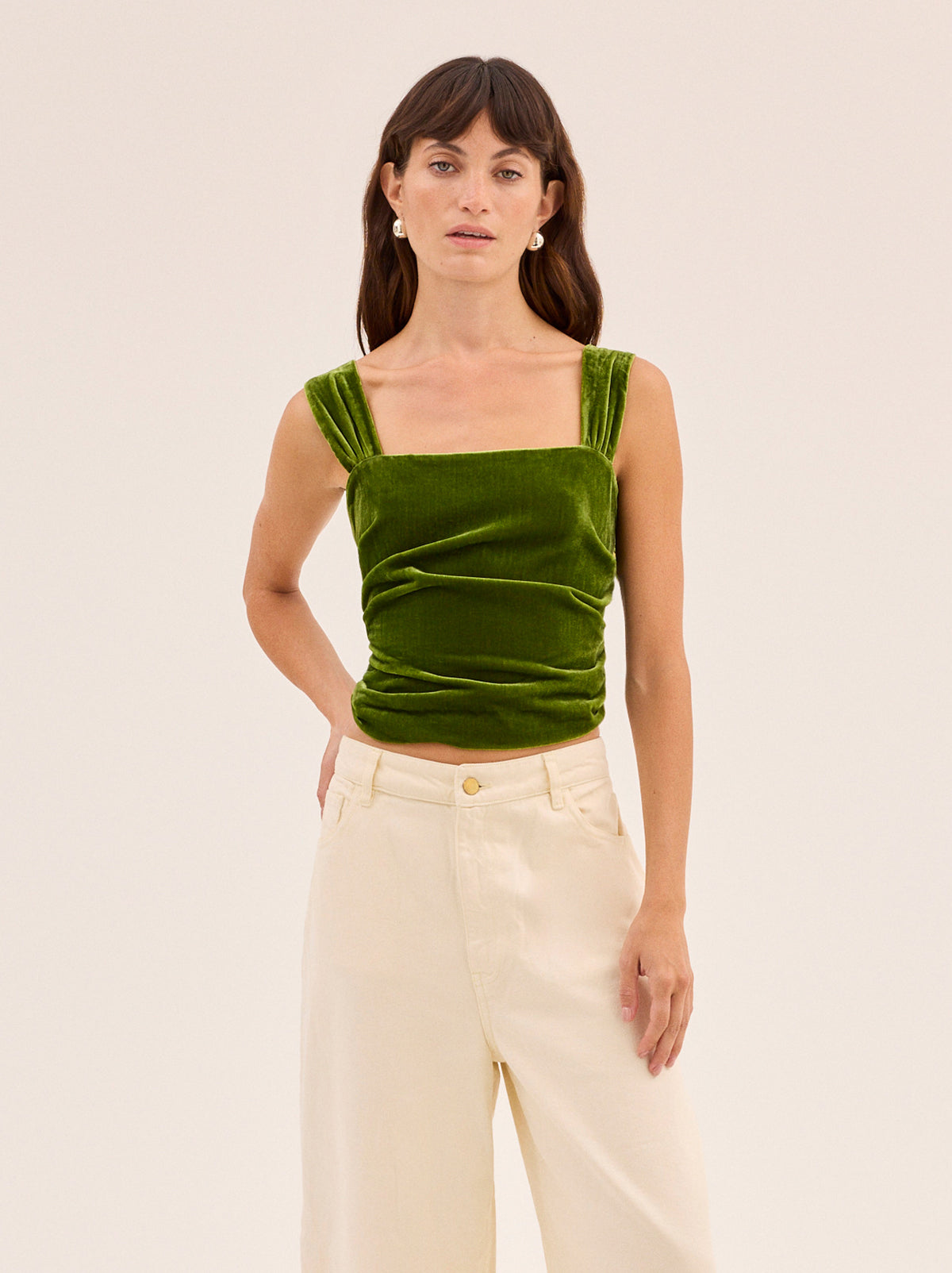 Beata Olive Velvet Top by Kitri Studio. Rich olive green velvet takes center stage in the Beata Top, offering a refined way to bring texture and depth into your wardrobe.  Cut from soft viscose velvet, the design features wide straps, a structured square neckline, and gentle folds across the bodice that skim the figure. Wide straps. Concealed side-zip. Shirring. 80% Viscose, 20% Nylon.