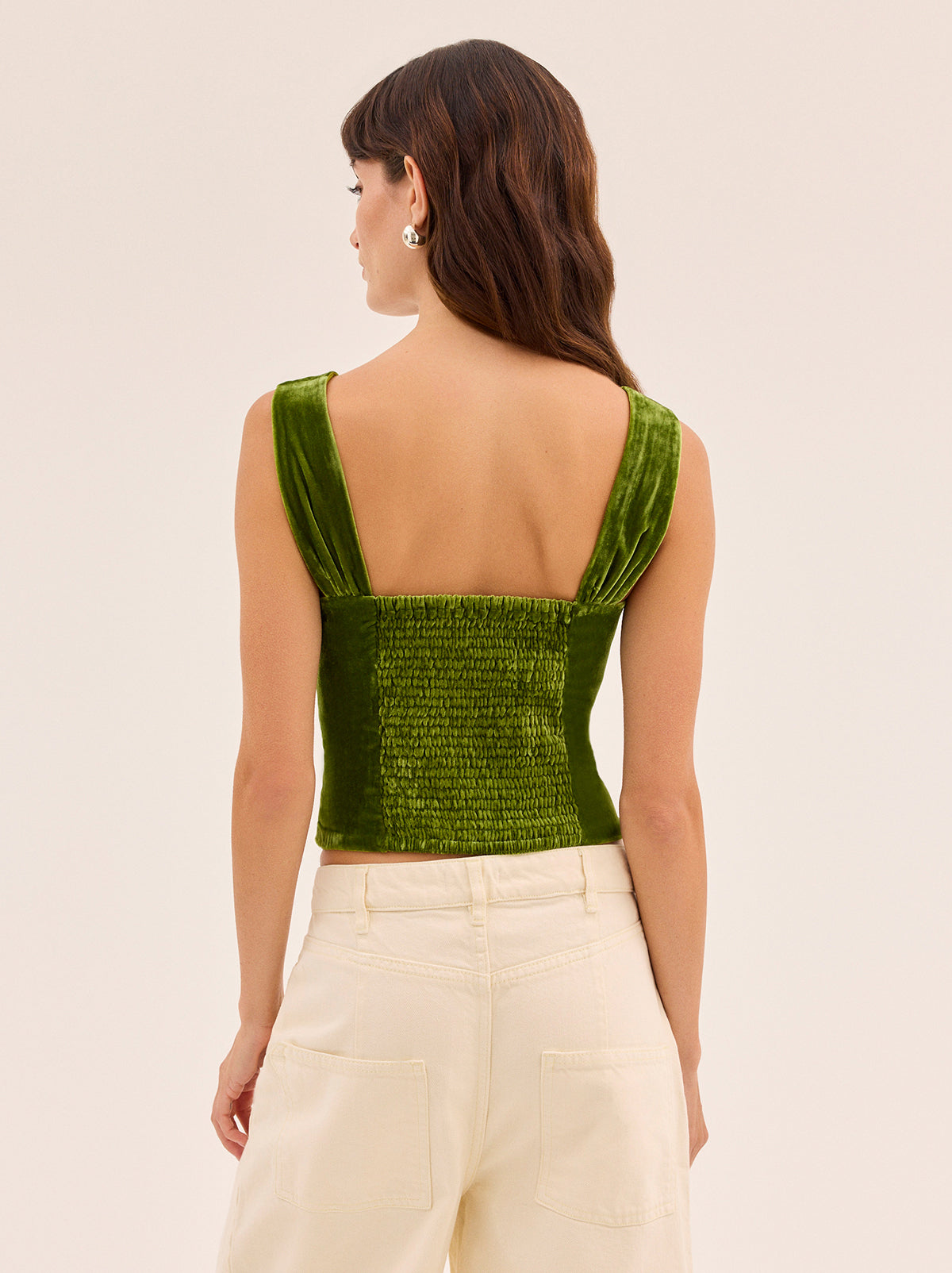 Beata Olive Velvet Top by Kitri Studio. Rich olive green velvet takes center stage in the Beata Top, offering a refined way to bring texture and depth into your wardrobe.  Cut from soft viscose velvet, the design features wide straps, a structured square neckline, and gentle folds across the bodice that skim the figure. Wide straps. Concealed side-zip. Shirring. 80% Viscose, 20% Nylon.