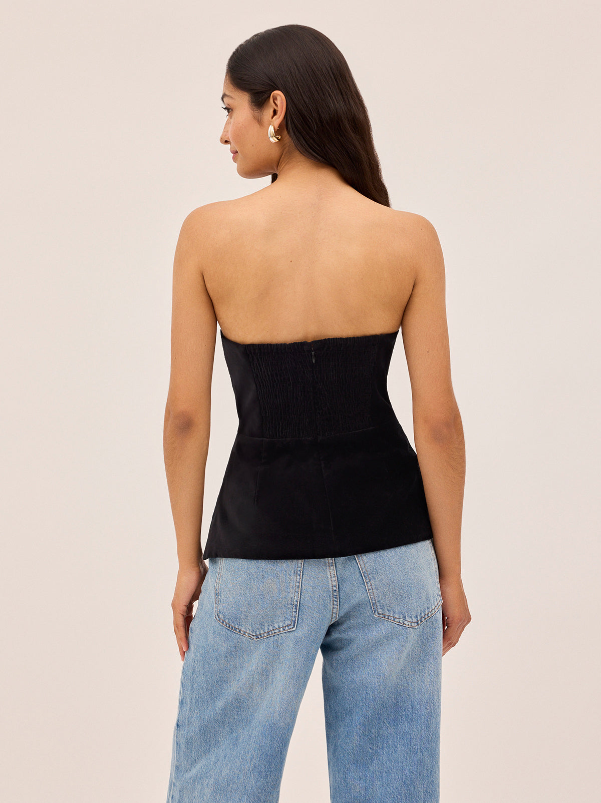 Bella Black Velvet Bandeau Top by Kitri Studio. A luxurious update on a KITRI favourite, this corset-inspired bandeau top is cut from black cotton velvet and reimagined for the winter party season.  Designed with striking ivory satin piping and a row of delicate satin bow details along one side, it offers both elegance and charm. strapless. Concealed side-zip. Fully lined. 100% Cotton Velvet.