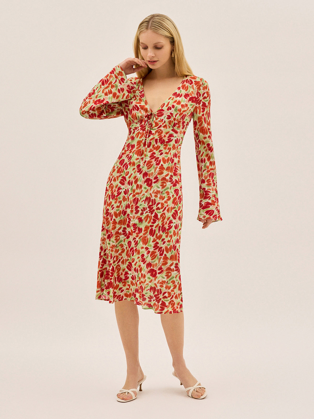 Carrie Tulip Print Dress by Kitri Studio. A fresh new silhouette for every RSVP.  The Carrie Tulip Print Dress features a flattering deep V-neckline with a soft bow tie detail, flared long sleeves, and a calf-length skirt. V-neck. Flared sleeves. Concealed side-zip. 100% Viscose Crepe.