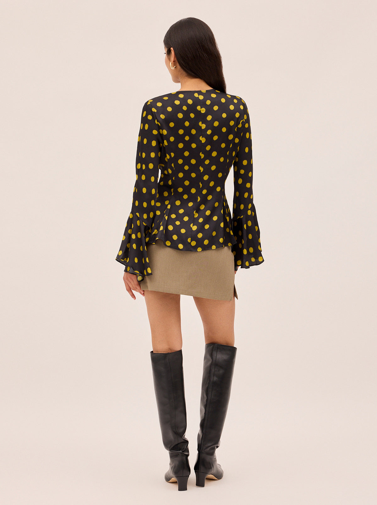 Chantelle Black Polka Dot Satin Top by Kitri Studio. The Chantelle top blends bohemian charm with modern polish in classic-with-a-twist chartreuse polka dot  print.  Crafted from lustrous and fluid viscose satin, it features flared sleeves, a wide neckline with delicate tie detail, and self-covered buttons through the front. Round neck. Flared sleeves. Button front. 100% Viscose.