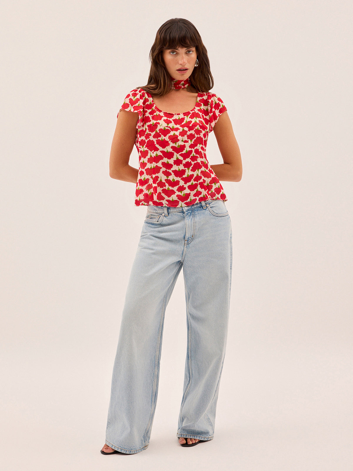 Clementina Carnation Print Top by Kitri Studio. A new-season silhouette, the Clementina top is crafted from lightweight, semi-sheer viscose georgette in our in-house designed carnation print.  Featuring a scooped neckline and delicate frilled short sleeves, it comes with a separate matching tie that can be styled at the neck or worn your way. Scoop neck. Short sleeves. Concealed side-zip. 100% Viscose Georgette.