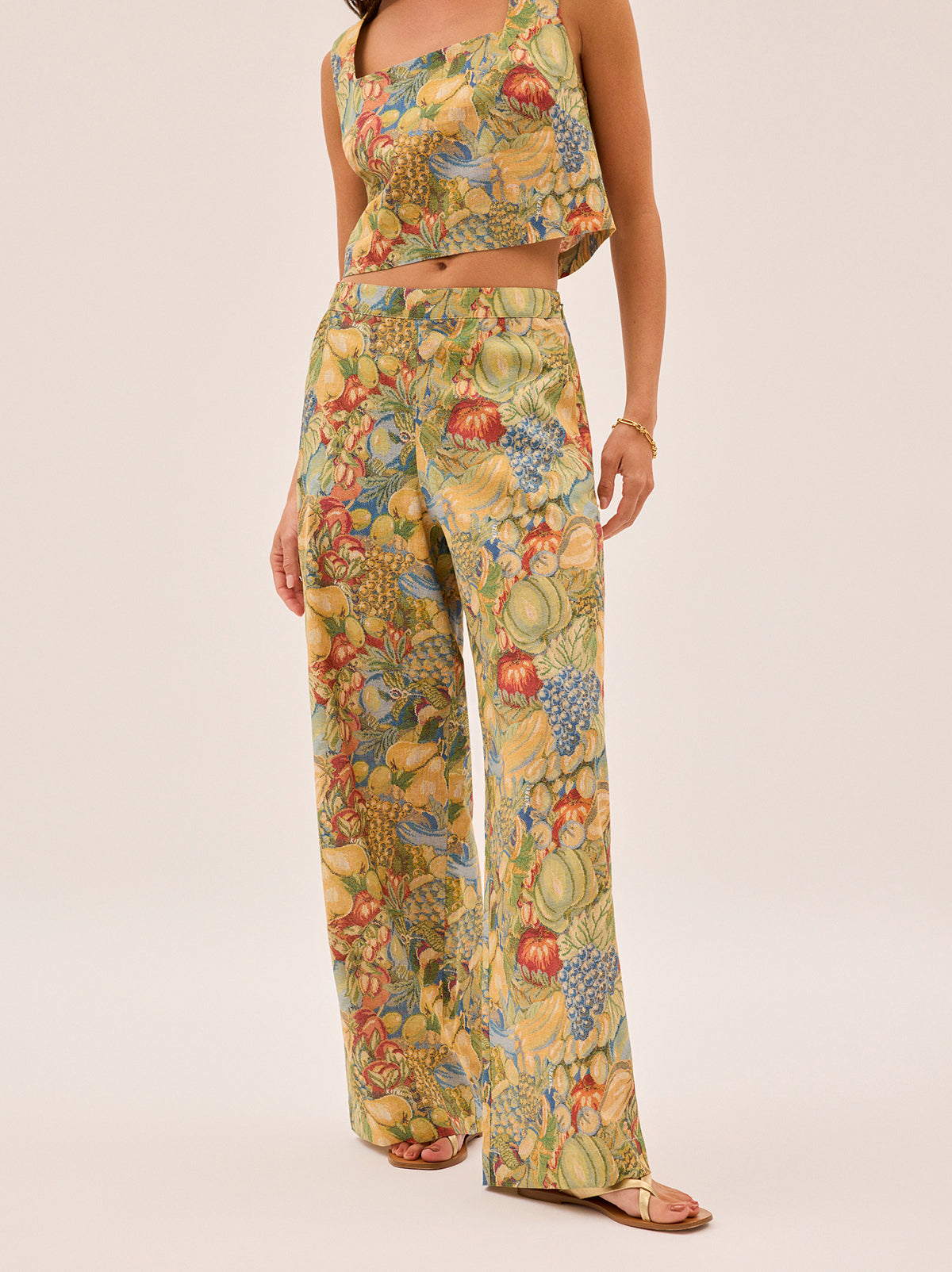 Cosima Fruit Print Trousers by Kitri Studio. A bestselling favourite with a playful twist.  The Cosima Trousers return in our joyful fruit print, cut in a wide-leg silhouette that’s equal parts polished and easygoing. Concealed side-zip. Slanted pockets. Mid Rise. 50% Cotton, 50% Linen.