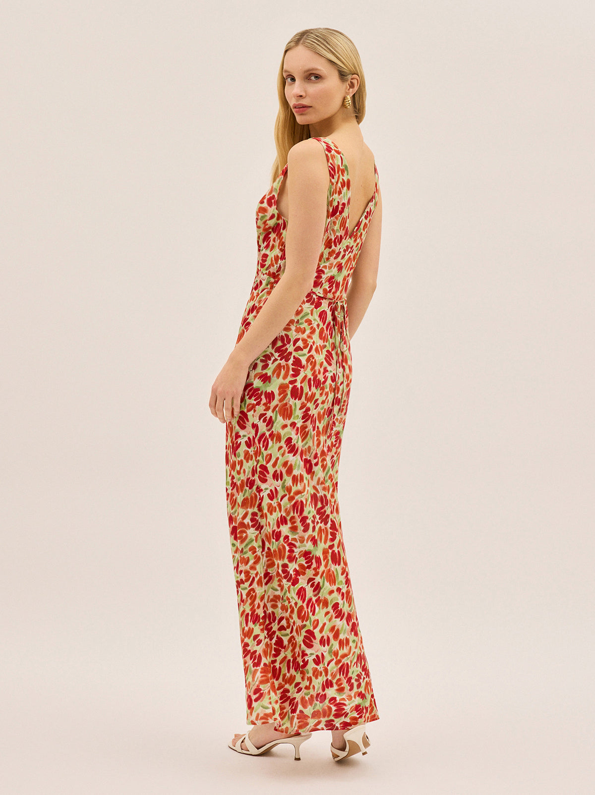 Danna Tulip Print Dress by Kitri Studio. The bestselling silhouette you know and love - now in a bold painterly tulip print.  The Danna Tulip Print Dress is cut on the bias for a beautifully skimming fit, with a deep V-neckline and a flattering tie at the back for added shape. V-neck. Sleeveless. Concealed side-zip. 100% Viscose Crepe.