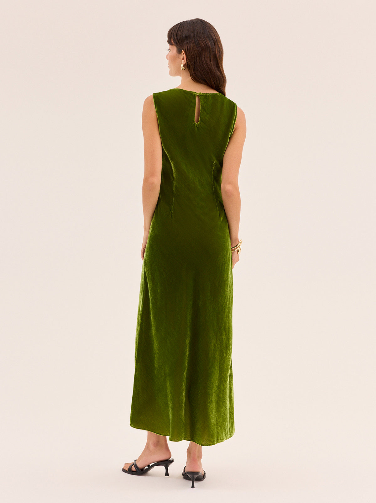 Elise Olive Velvet Dress by Kitri Studio. Cut on the bias for a flattering, fluid drape, the Elise in olive green viscose velvet is '90s-inspired dream dress.  The minimalist silhouette with the scoop neckline and clean lines make it an easy, versatile choice for day-to-night dressing. Scoop neck. Sleeveless. Concealed side-zip. 80% Viscose, 20% Nylon.