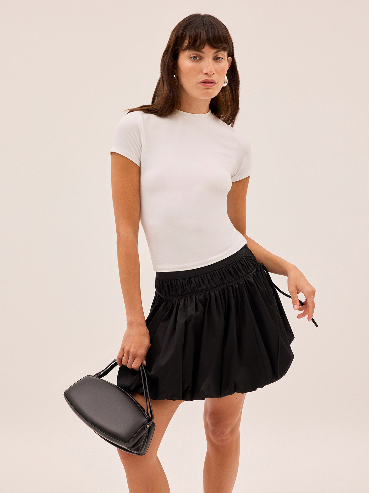 Hadley Black Cotton Mini Bubble Skirt by Kitri Studio. Fall in love with Hadley.  Crafted from a mid-weight black cotton fabrication she’s an elegant update on the bubble hem skirt, featuring a flirty gathered mini skirt with a tie detail for a feminine touch. Concealed side-zip. Fully lined. Length: Mini. 100% Cotton.