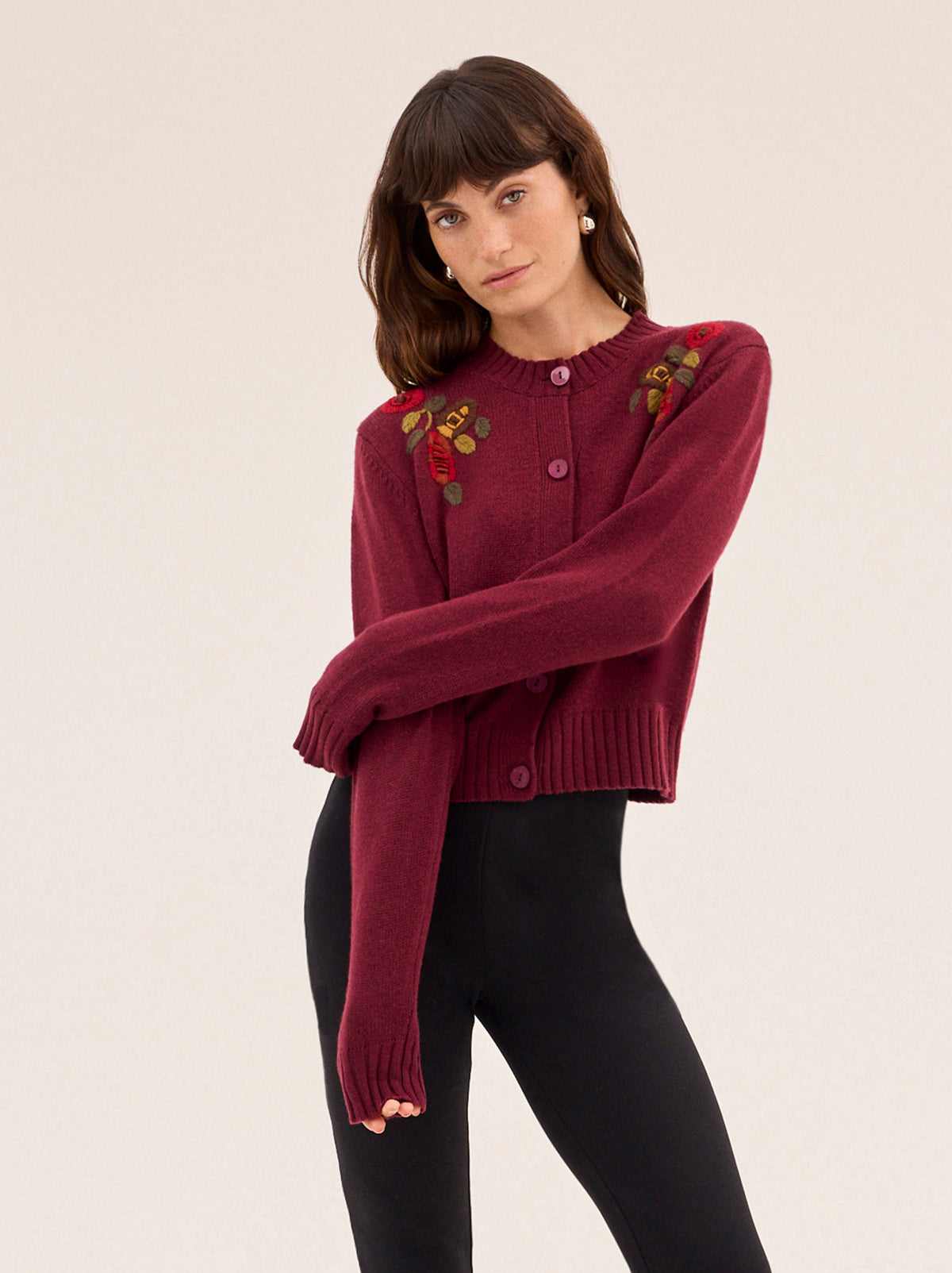 Isla Burgundy Hand-Embroidered Cardigan by Kitri Studio. A timeless layer with artisanal charm, this vintage-inspired cardigan is knitted from a soft wool and cashmere blend for a luxurious feel.  Designed in a rich burgundy hue, it features a classic round neckline, relaxed fit, and intricate hand-embroidered floral details across the front. Round neck. Long sleeves. Button front. 5% Cashmere, 20% Wool, 27% Viscose, 48% Nylon.