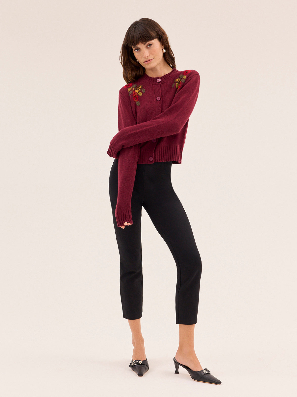 Isla Burgundy Hand-Embroidered Cardigan by Kitri Studio. A timeless layer with artisanal charm, this vintage-inspired cardigan is knitted from a soft wool and cashmere blend for a luxurious feel.  Designed in a rich burgundy hue, it features a classic round neckline, relaxed fit, and intricate hand-embroidered floral details across the front. Round neck. Long sleeves. Button front. 5% Cashmere, 20% Wool, 27% Viscose, 48% Nylon.
