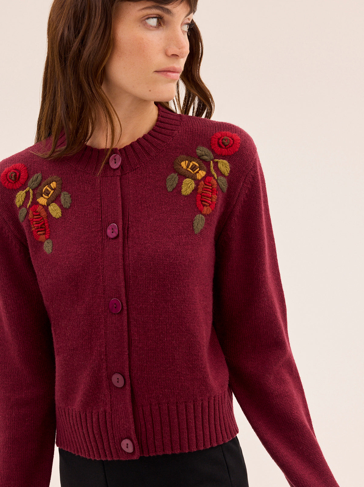 Isla Burgundy Hand-Embroidered Cardigan by Kitri Studio. A timeless layer with artisanal charm, this vintage-inspired cardigan is knitted from a soft wool and cashmere blend for a luxurious feel.  Designed in a rich burgundy hue, it features a classic round neckline, relaxed fit, and intricate hand-embroidered floral details across the front. Round neck. Long sleeves. Button front. 5% Cashmere, 20% Wool, 27% Viscose, 48% Nylon.