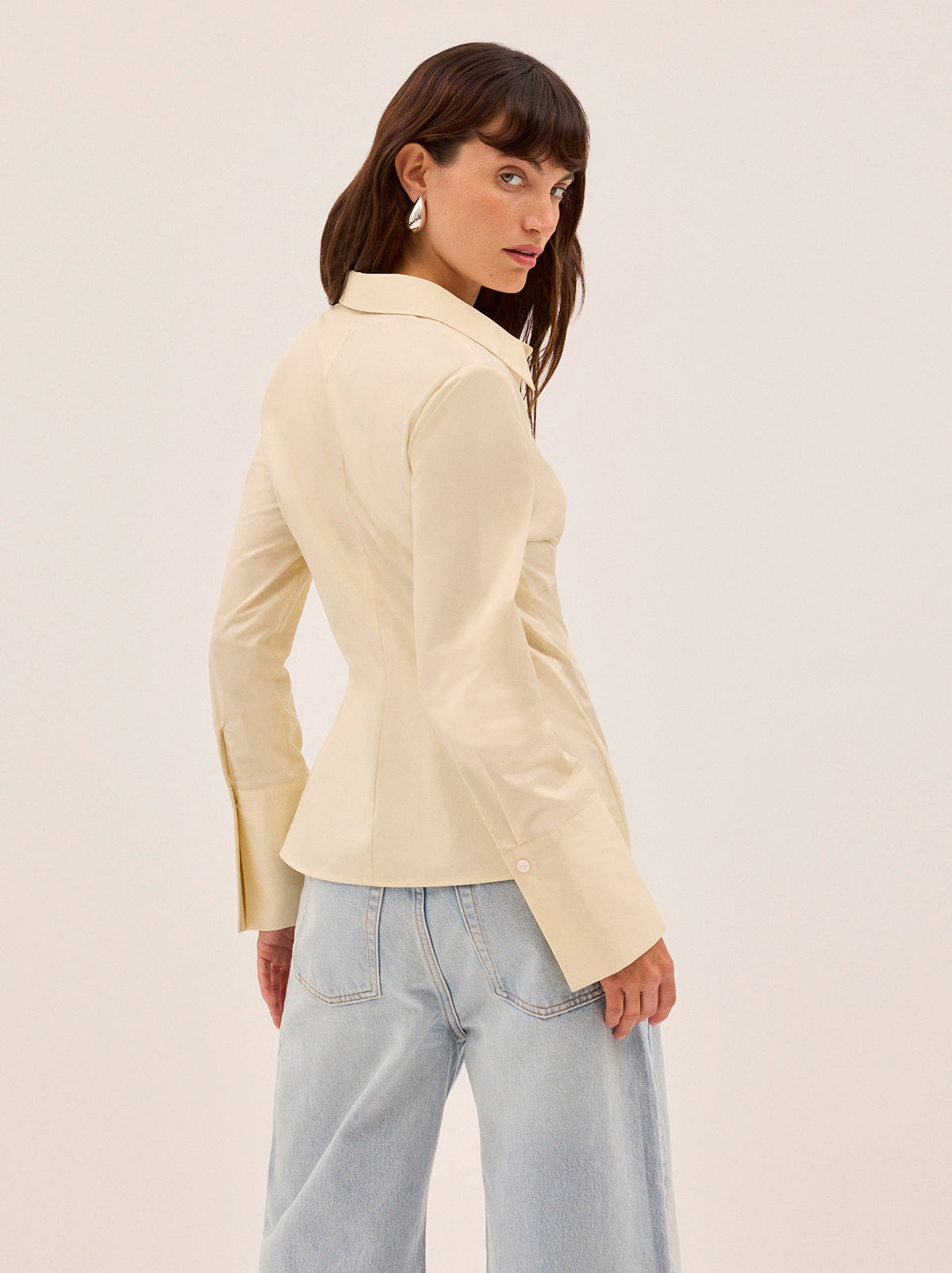 Jesse Vanilla Cotton Shirt by Kitri Studio. A refined take on a wardrobe classic.  The Jesse shirt debuts a new silhouette, cut from mid-weight 100% cotton in a soft vanilla hue. Collared neckline. Flared sleeves. Buttoned cuffs. 100% Cotton.