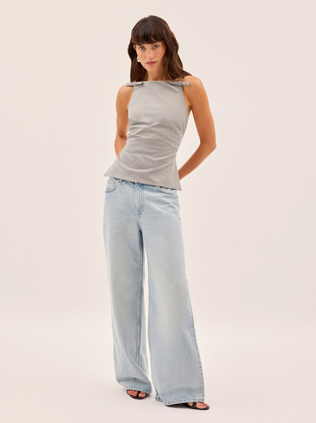 Josie Grey Tie Back Top by Kitri Studio. A standout new silhouette, the Josie top is crafted from soft deadstock tailoring fabric that feels as good as it looks.  Designed with a high square neckline and feminine bow details at the shoulders, it features a striking open back with adjustable ties that can be styled multiple ways. Straight neckline. Spaghetti straps. Back ties. 63% Polyester, 34% Viscose, 3% Elastane.