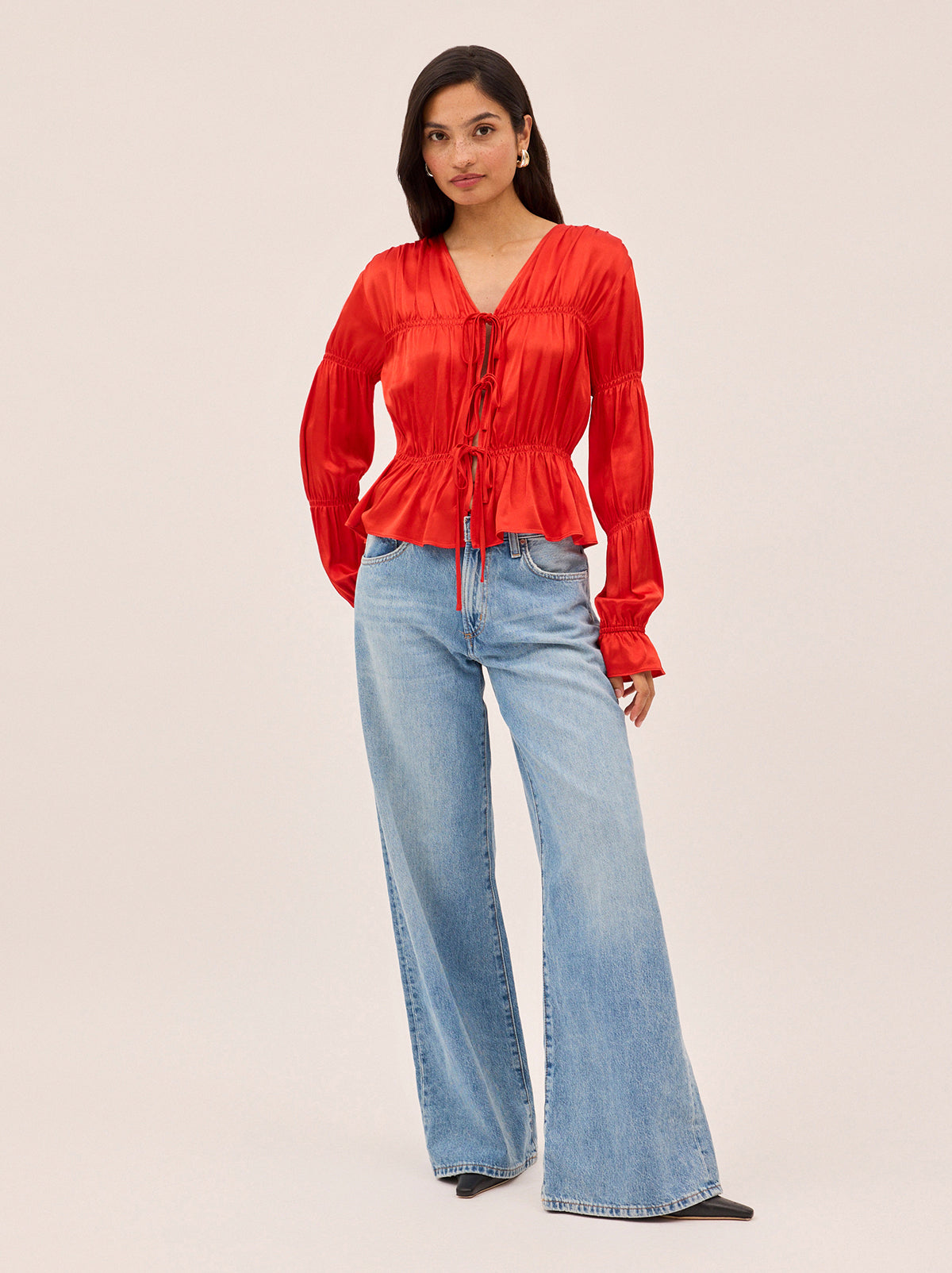 Maia Red Satin Top by Kitri Studio. Vintage-inspired with a modern edge, the Maia Top in brilliant red is here to elevate your wardrobe.  Designed in luxurious satin with a flattering gathered bodice and sleeves, this long-sleeve blouse brings effortless femininity to any look. V-neck. Long sleeves. Elasticated cuffs. 100% Viscose Satin.