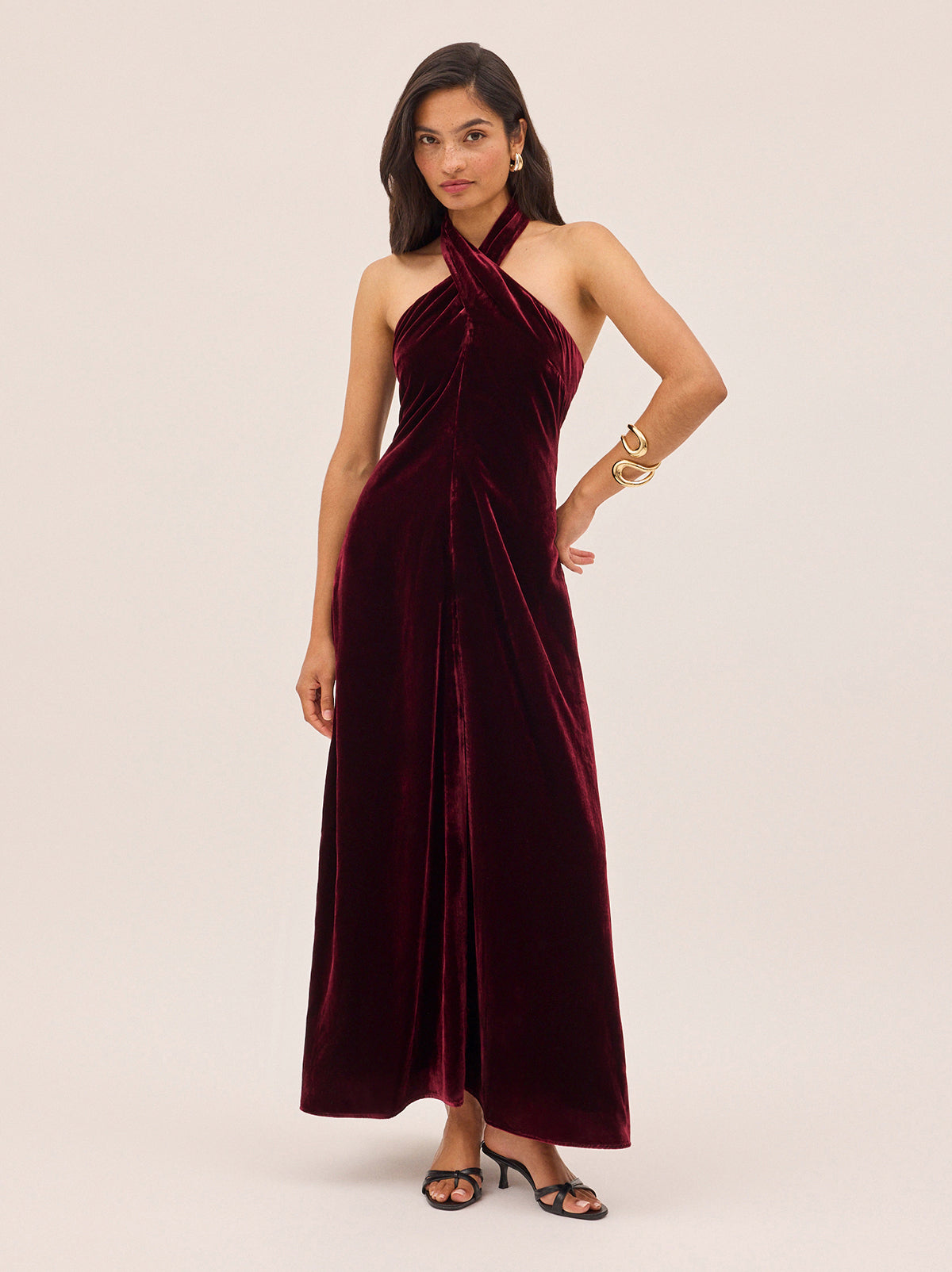 Neve Burgundy Velvet Halter Dress by Kitri Studio. A statement for the season, the Neve Dress is crafted from rich burgundy viscose velvet that drapes beautifully for an effortless yet elevated look.  This bestselling silhouette features a cross-front halterneck that ties elegantly at the back, creating a flattering open-back effect. halter neck. sleeveless. A-line skirt. 80% Viscose, 20% Nylon.