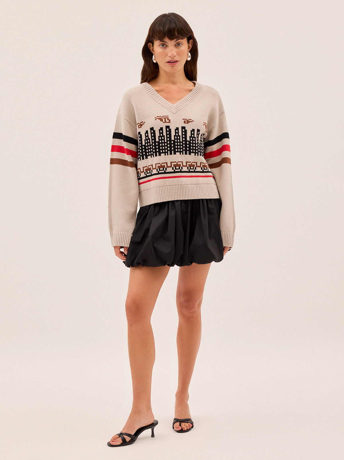 Noa City Intarsia Knit Jumper by Kitri Studio. The Noa jumper is a playful addition to your transitional wardrobe.  Designed for standout layering, it's knitted from a soft cotton, nylon, and wool blend and features a wide V-neckline and relaxed fit. V-neck. Long sleeves. Ribbed cuffs. 60% Cotton, 30% Nylon, 10% Wool.