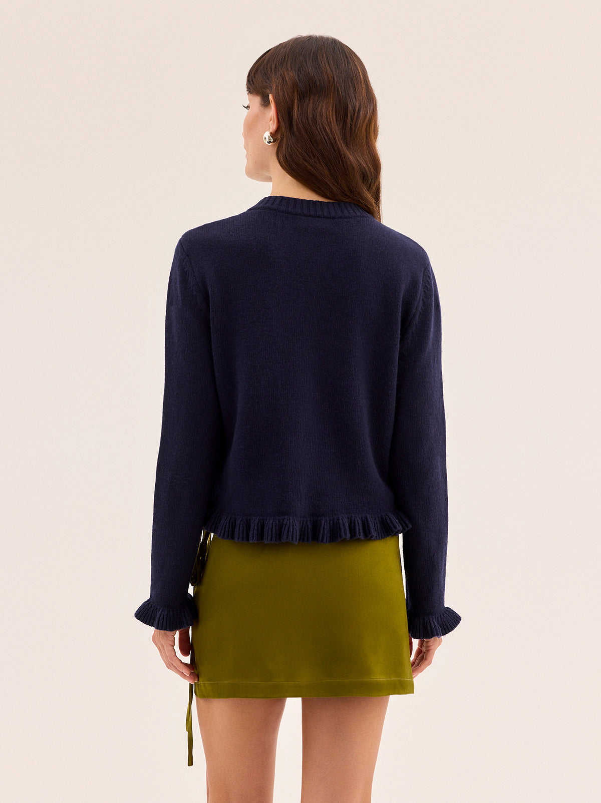 Odille Navy Knit Cardigan by Kitri Studio. The Odile cardigan is a refined wardrobe staple with a playful twist.  Knitted from a soft, mid-weight cashmere blend, it features a classic button-down front, with delicate frill detailing at the hem and cuffs. Round neck. Long sleeves. Frilled cuffs. 48% Nylon, 27% Viscose, 20% Wool, 5% Cashmere.