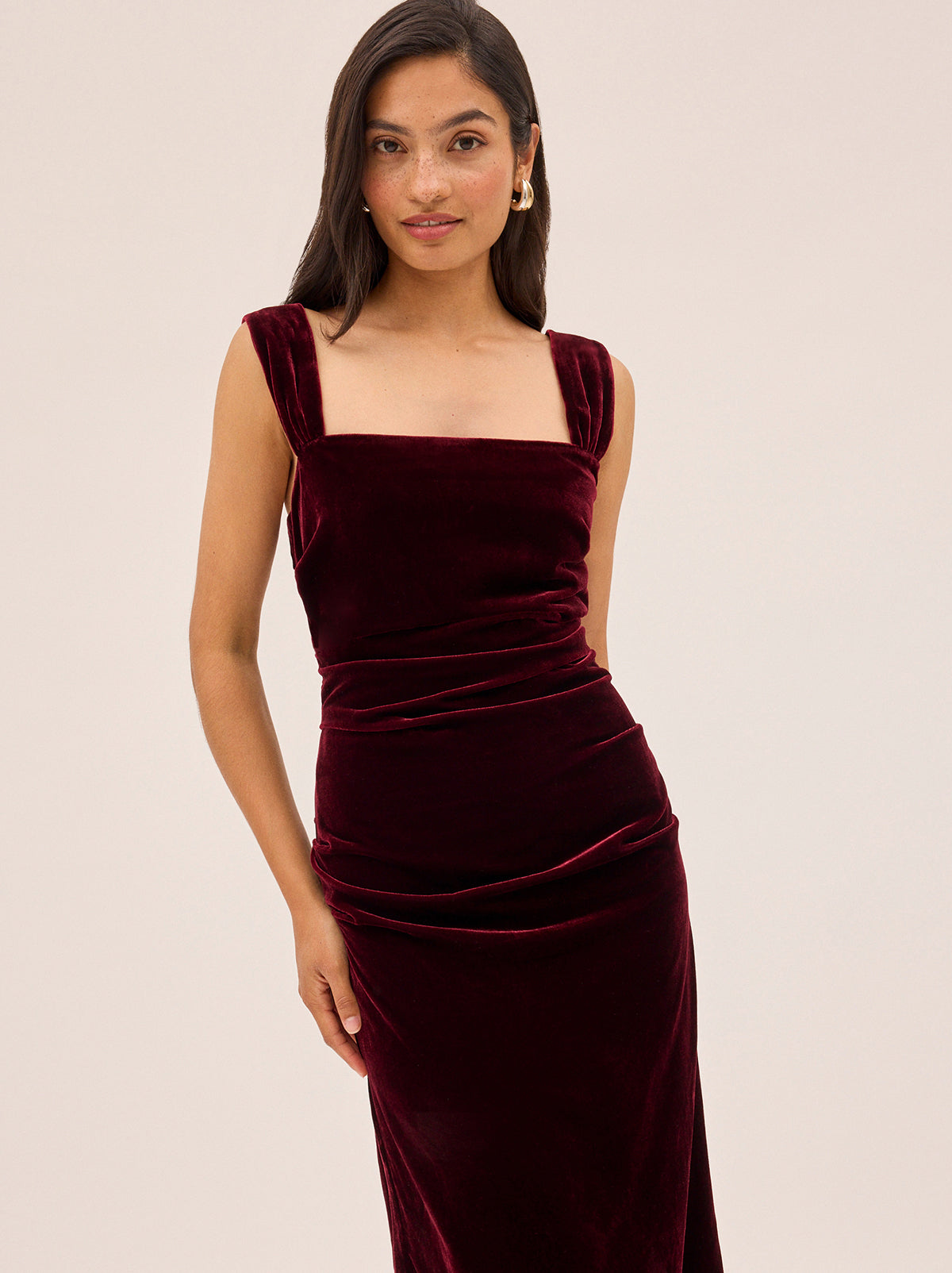 Rita Burgundy Velvet Dress by Kitri Studio. Retro-inspired and effortlessly flattering.  The Rita Burgundy Velvet Dress is crafted from a soft viscose velvet in rich burgundy hue, with wide gathered straps and gentle ruching through the bodice for a sculpted, feminine fit. Straight neckline. sleeveless. Back-zip. 80% Viscose, 20% Nylon.