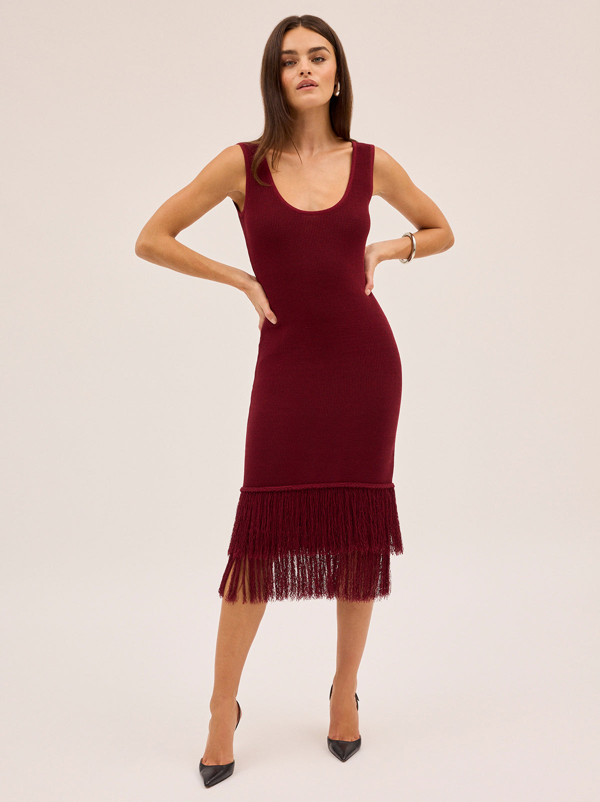 Sandra Red Knit Dress by Kitri Studio. Sandra Dress in sultry dark red offers a body-skimming silhouette that moves effortlessly with you.  Designed with a flattering round neckline, sleeveless cut and double fringe detail at the hem, it radiates a 1920s-inspired charm, perfect for party season or any occasion that calls for a statement piece. Scoop neck. Wide straps. Length: Midi. 68% Cotton, 32% Nylon.