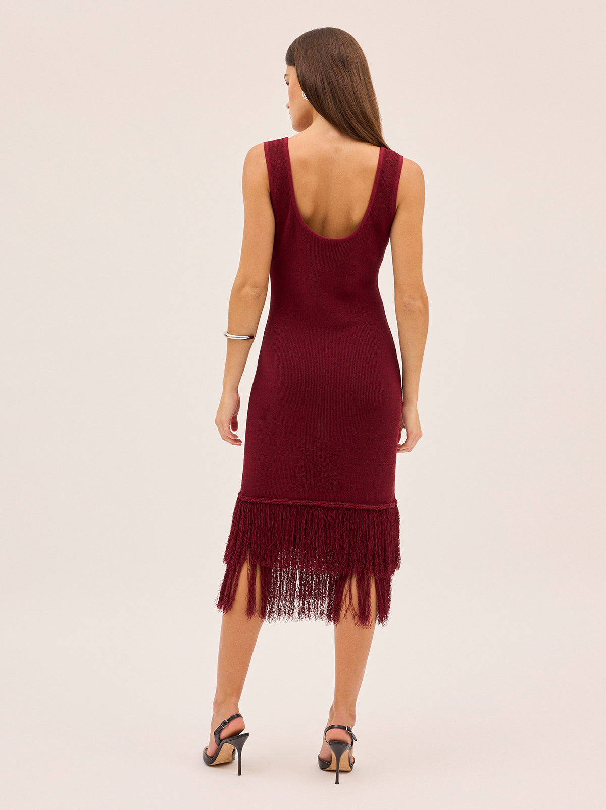 Sandra Red Knit Dress by Kitri Studio. Sandra Dress in sultry dark red offers a body-skimming silhouette that moves effortlessly with you.  Designed with a flattering round neckline, sleeveless cut and double fringe detail at the hem, it radiates a 1920s-inspired charm, perfect for party season or any occasion that calls for a statement piece. Scoop neck. Wide straps. Length: Midi. 68% Cotton, 32% Nylon.