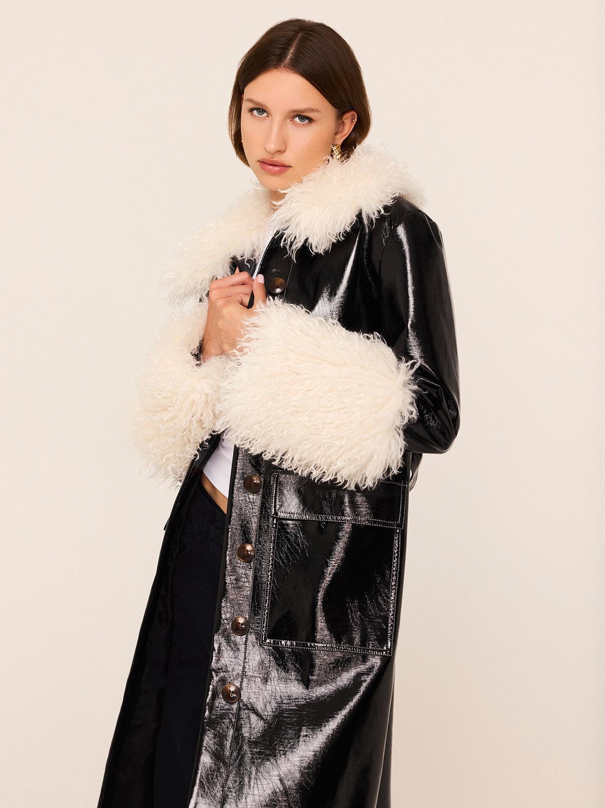 Simone Black Vinyl Coat - Simone is a black vintage-inspired vinyl coat with a removable faux-fur collar and cuffs for extra versatility. A relaxed fit with large patch pockets at the front, it comes with a buckled belt to cinch in at the waist. 