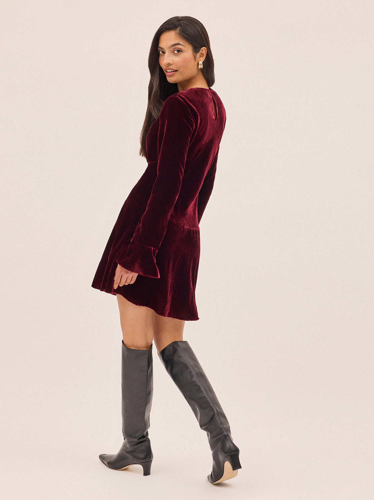 Stefania Burgundy Velvet Mini Dress by Kitri Studio. Flirty, fun, and effortlessly chic—the Stefania Mini Dress is your new go-to for day-to-night dressing.  Crafted in deep burgundy velvet, this long-sleeve mini dress features fluted cuffs and a softly flared hem for the perfect touch of movement. Round neck. Flared sleeves. A-line skirt. 80% Viscose, 20% Nylon.