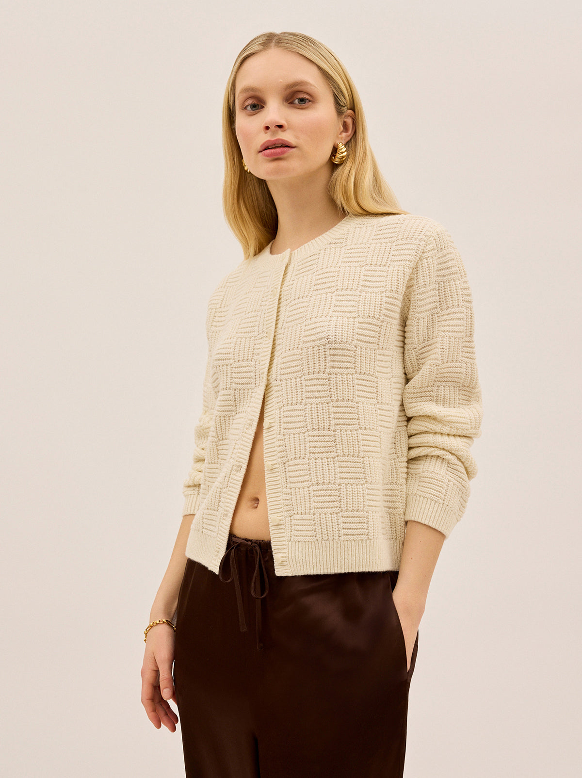 Terri Ivory Knit Cardigan by Kitri Studio. A modern take on a wardrobe classic.  The Terri cardigan is crafted from a soft textured knit with a geometric pattern woven throughout adding depth to an everyday layer. Round neck. Long sleeves. Button front. 40% Acrylic, 30% Nylon, 30% Wool.