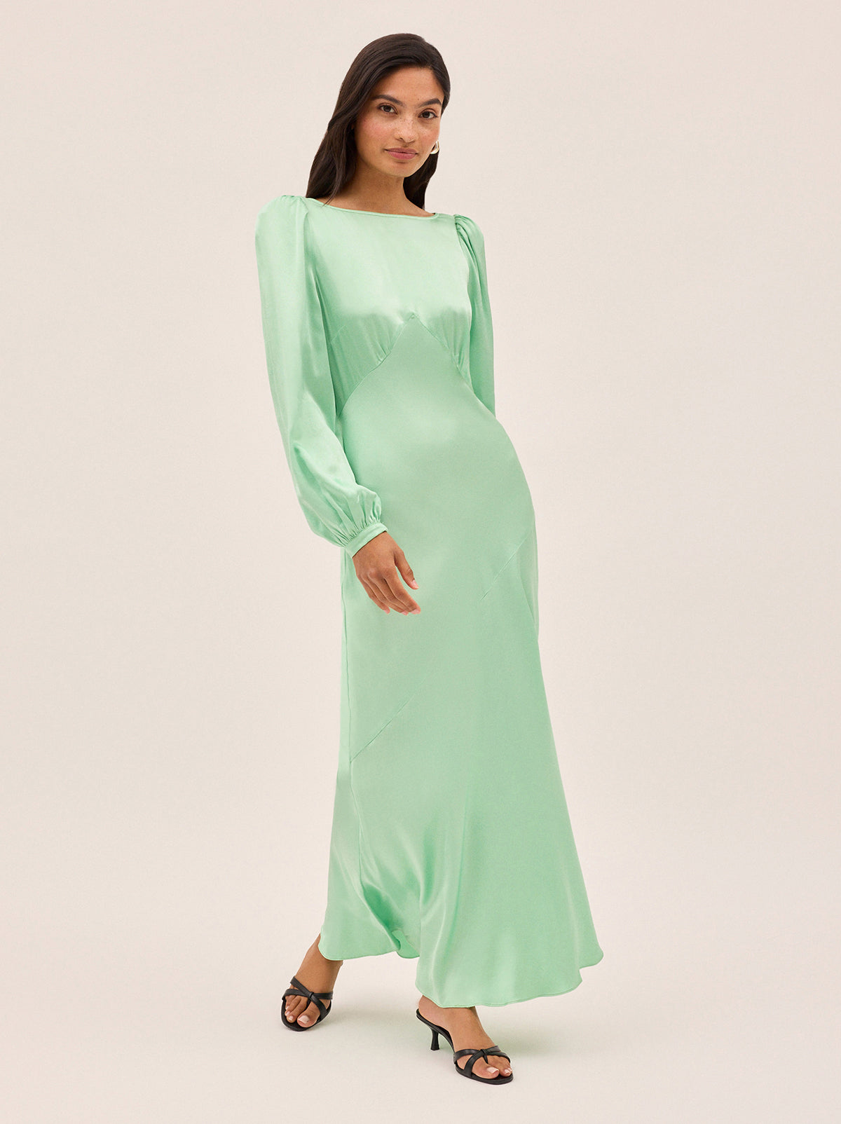 Yara Mint Satin Dress by Kitri Studio. Slip into timeless elegance with this flowing Yara Mint Satin Maxi Dress, designed to turn heads from every angle.  Cut on the bias for a beautifully fluid drape, the skirt features subtle panel detailing and a flattering waist seam that defines your silhouette. Slash Neck. Long sleeves. Bias cut. 100% Viscose Satin.