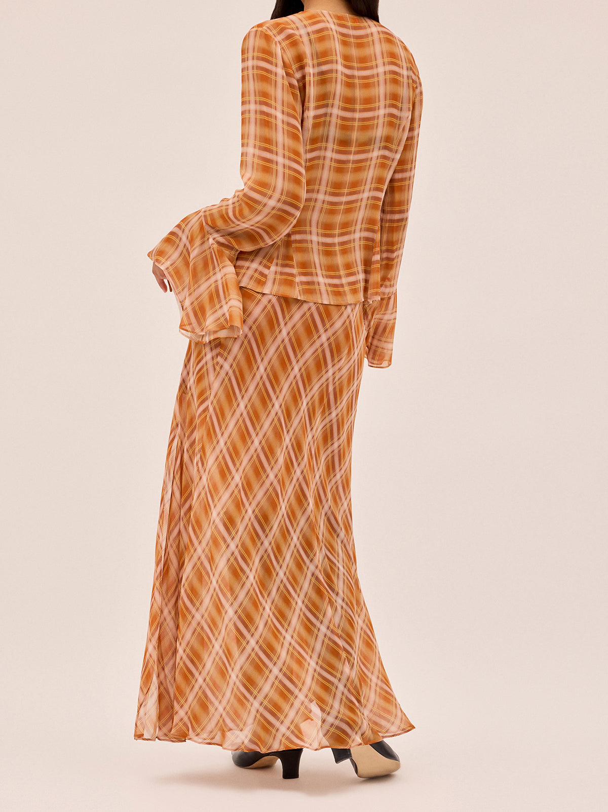 Zoe Apricot Check Print Skirt by Kitri Studio. The Zoe skirt is a flowing, feminine maxi crafted from semi-sheer viscose georgette in our exclusive apricot check print.  Designed with a mid-rise fit, it features a leg-baring split and is half lined for just the right amount of coverage. Half-lined. Elasticed waist. Flared skirt. 100% Viscose Georgette.