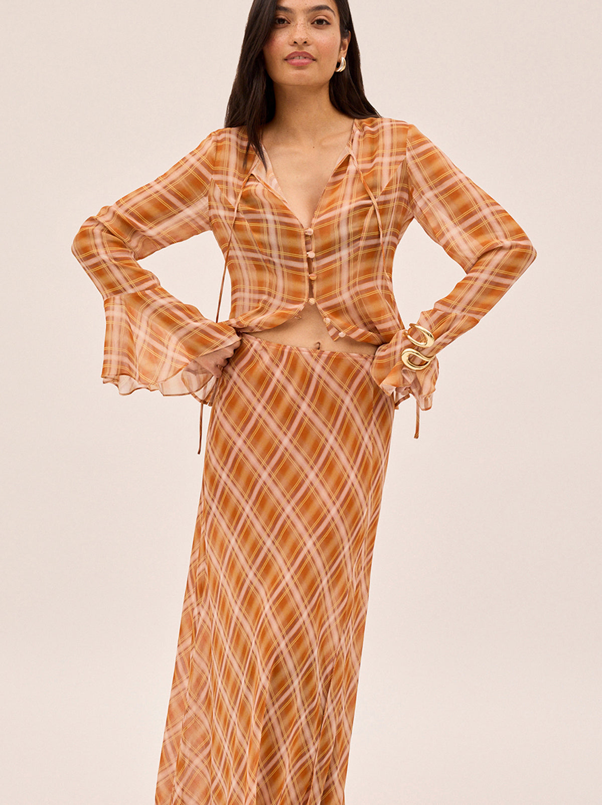 Zoe Apricot Check Print Skirt by Kitri Studio. The Zoe skirt is a flowing, feminine maxi crafted from semi-sheer viscose georgette in our exclusive apricot check print.  Designed with a mid-rise fit, it features a leg-baring split and is half lined for just the right amount of coverage. Half-lined. Elasticed waist. Flared skirt. 100% Viscose Georgette.