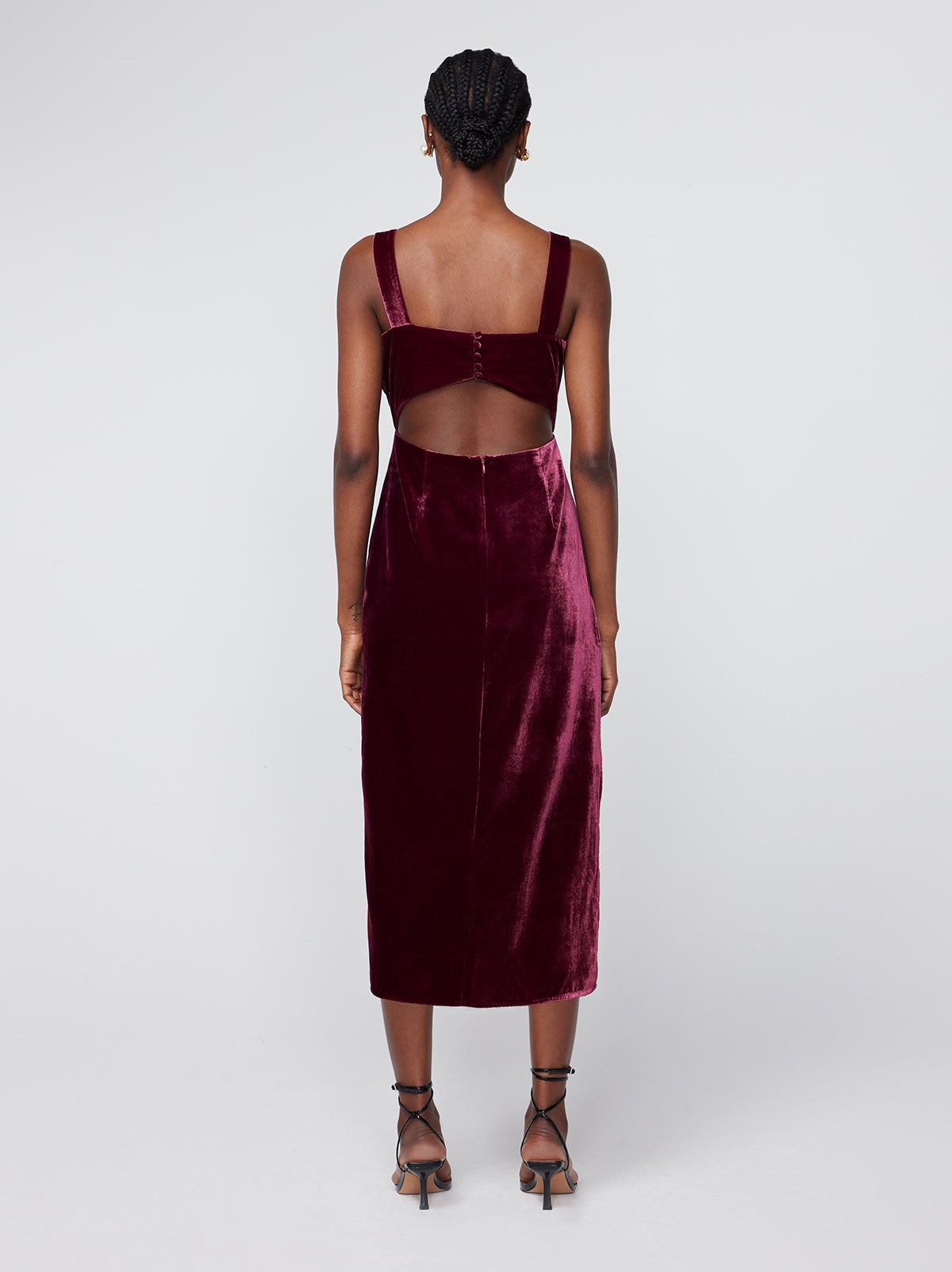 Aretha Burgundy Velvet Dress By KITRI Studio in a deep burgandy/maroon velvet fabric. A sultry midi length party dress ideal for Christmas/festive parties and other occasions. Featuring wide straps, open back detail and thigh split, this glamourous dress is as elegant as it is flattering. Best paired with stilletoes
