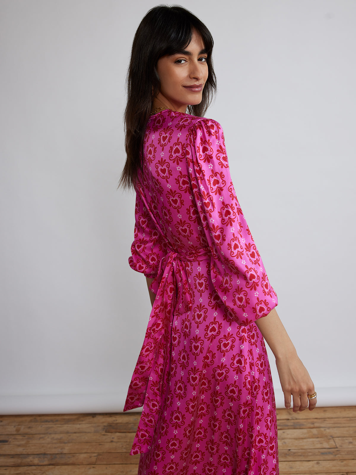 Aurora Pink Heart Print Maxi Dress By KITRI Studio is our bestselling, trending dress. A maxi party dress bursting with 70s style with its standout retro pink hearts printed fabric has voluminous flowy sleeves & cross-cross ribbon tie belt. A longline floaty summer dress, ideal for weddings and special occasions - as well as a popular pregnancy dress option