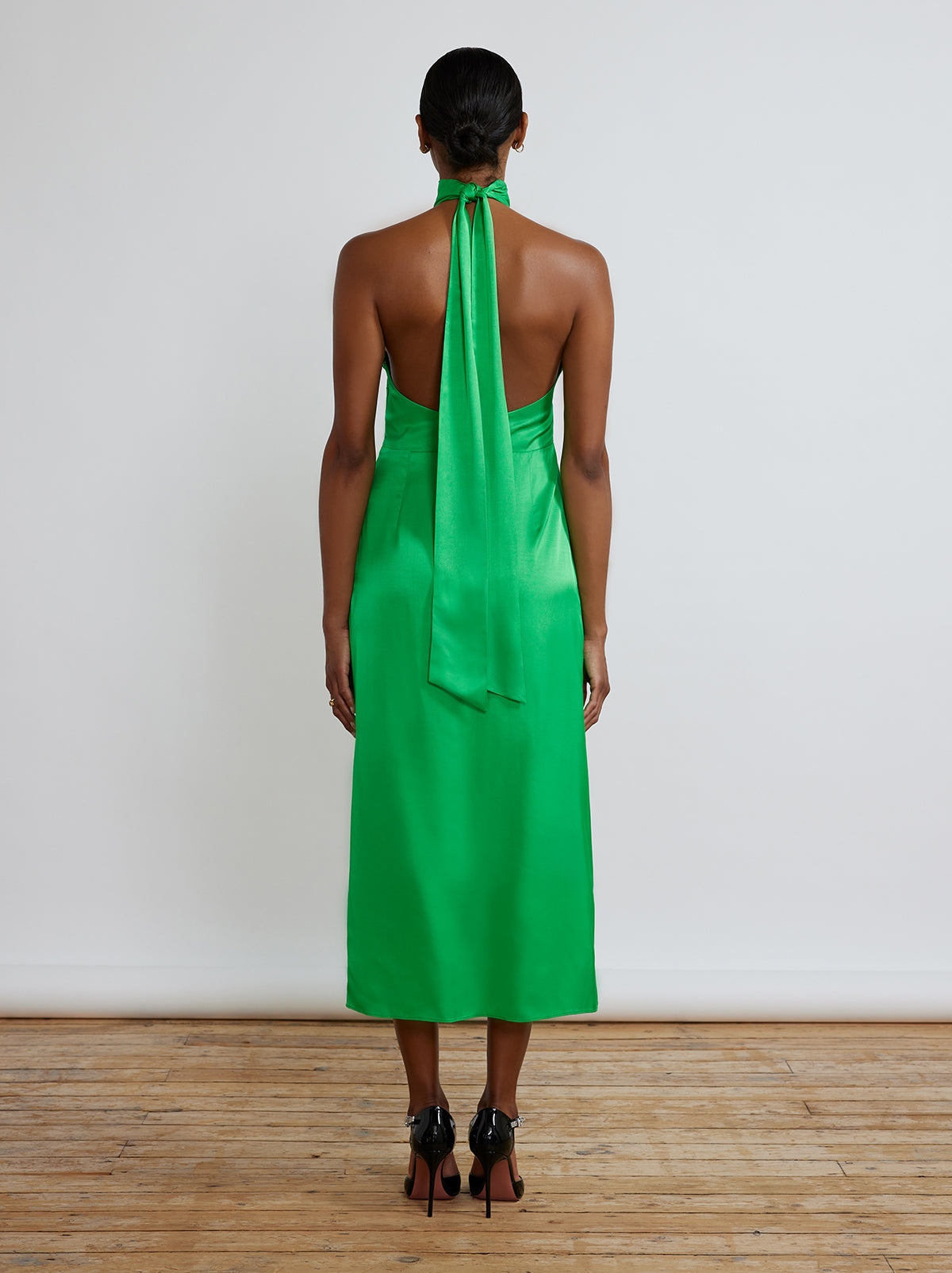 The Gwen Halterneck Dress By KITRI Studio in solid emerald green makes a perfect bridesmaid dress. Statement midi dress with sleeveless and backless halterneck design and waist length scarf/ribbon at the back.