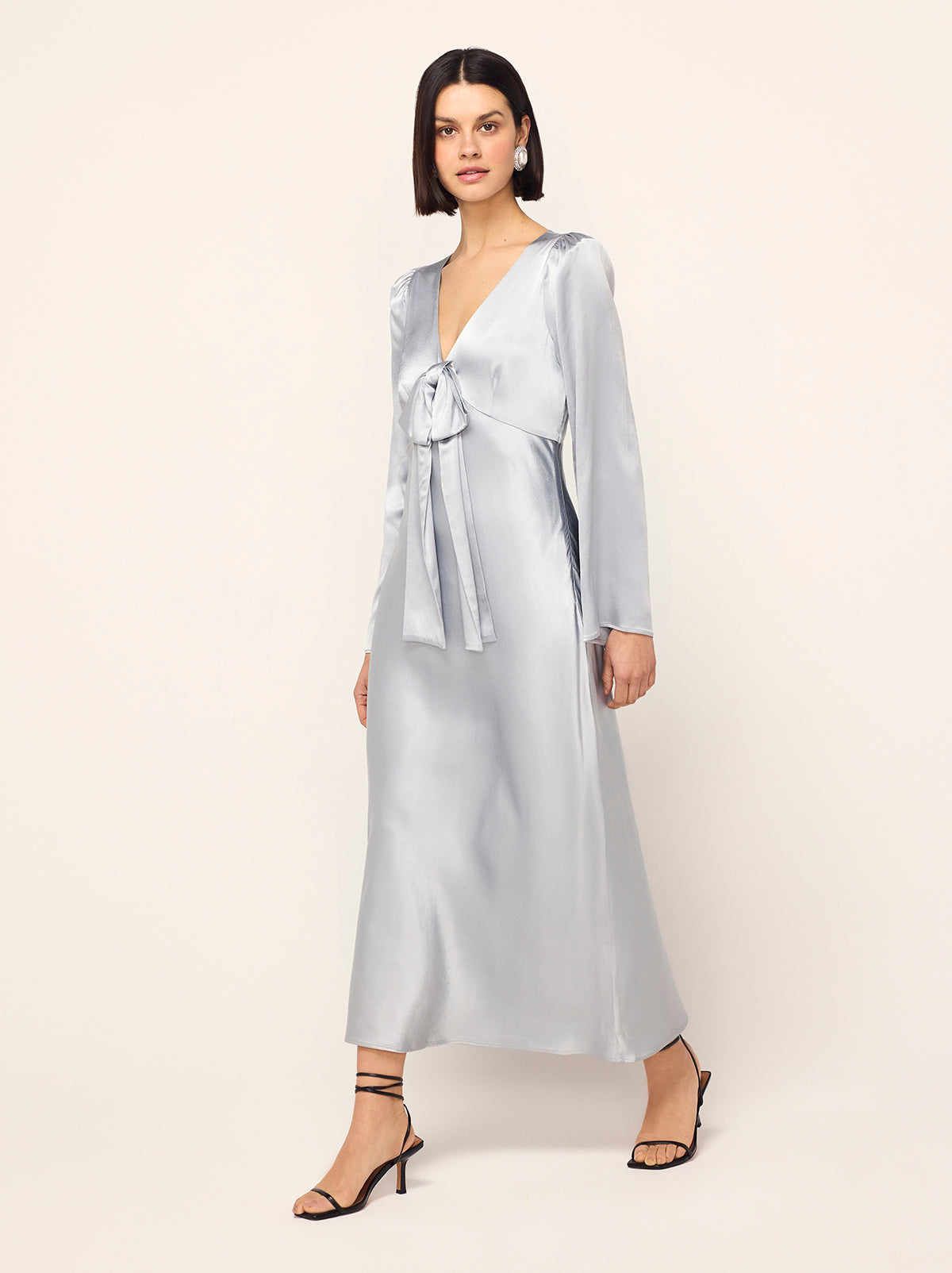 Lily Silver Satin Bow Dress - Lily is a flattering midi dress with an elegant silhouette and fluted sleeves. Her icy silver fabrication catches the light and creates a beautiful drape. Her darted bustline keeps things comfortable and her bow detail adds touch of theatre. 