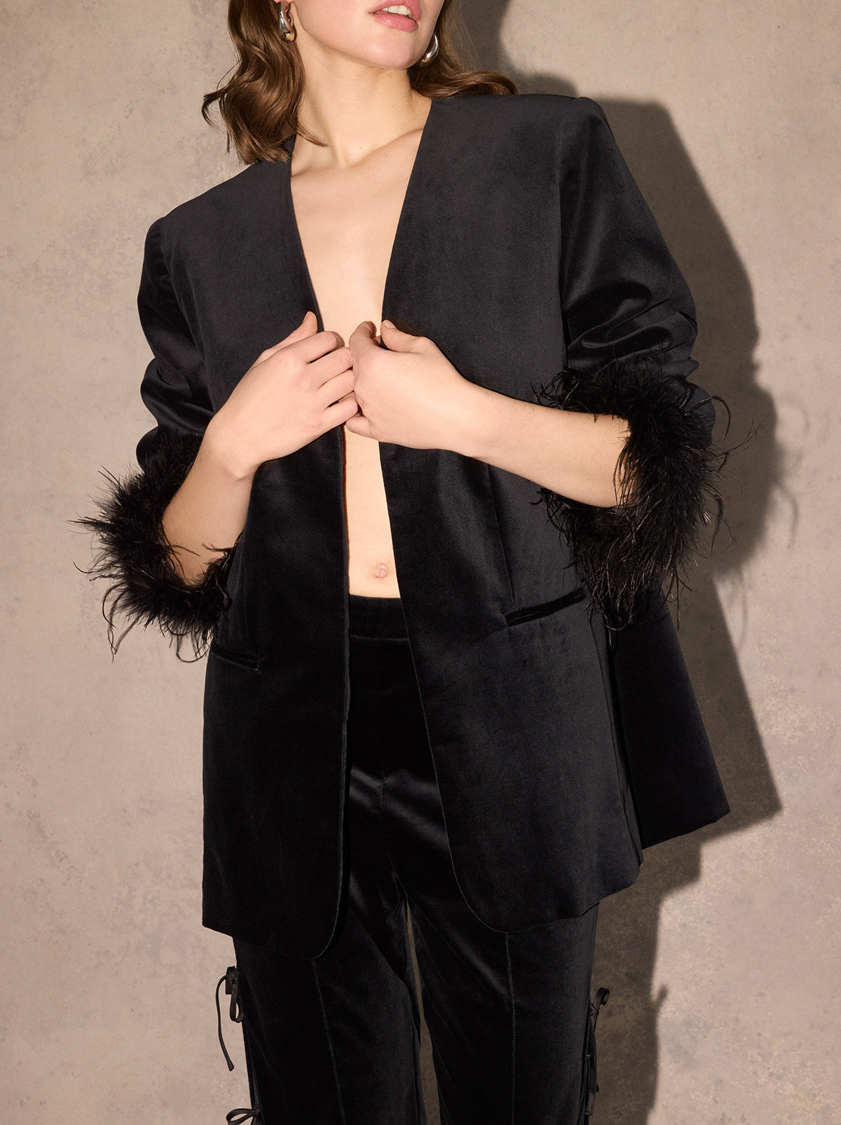 Marlene Black Velvet Feather Blazer - Marlene is an elegant, boxy blazer featuring detachable feather cuffs for multiple ways to wear. Crafted from our new cotton-blend velvet, she is structured whilst still feeling soft to the touch. Pair with co-ordinating Rosamund Black Velvet Trousers and Lou Lou Black Velvet Feather Top.