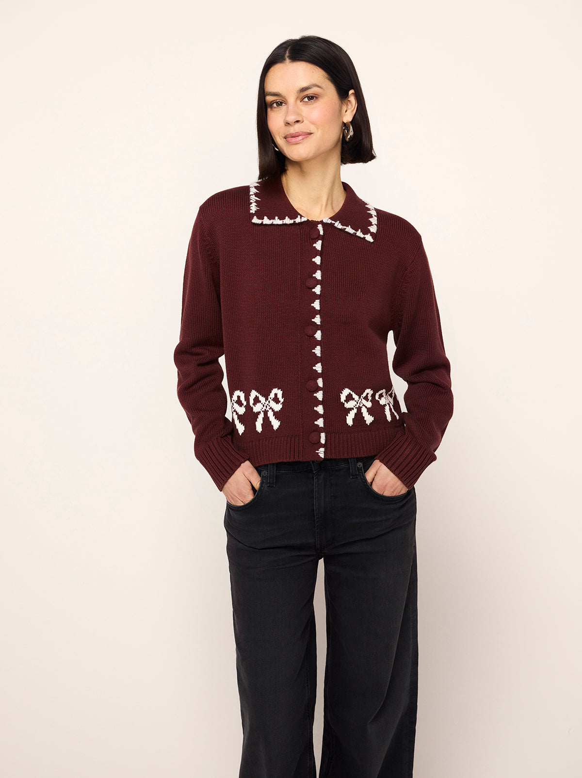 Polly Oxblood Bow Knit Cardigan - Polly is an oxblood cardigan with a contrasting ivory bow intarsia and crafted from a cosy cotton blend. Her ribbed sleeves and self-covered buttons make her a cut above the rest.