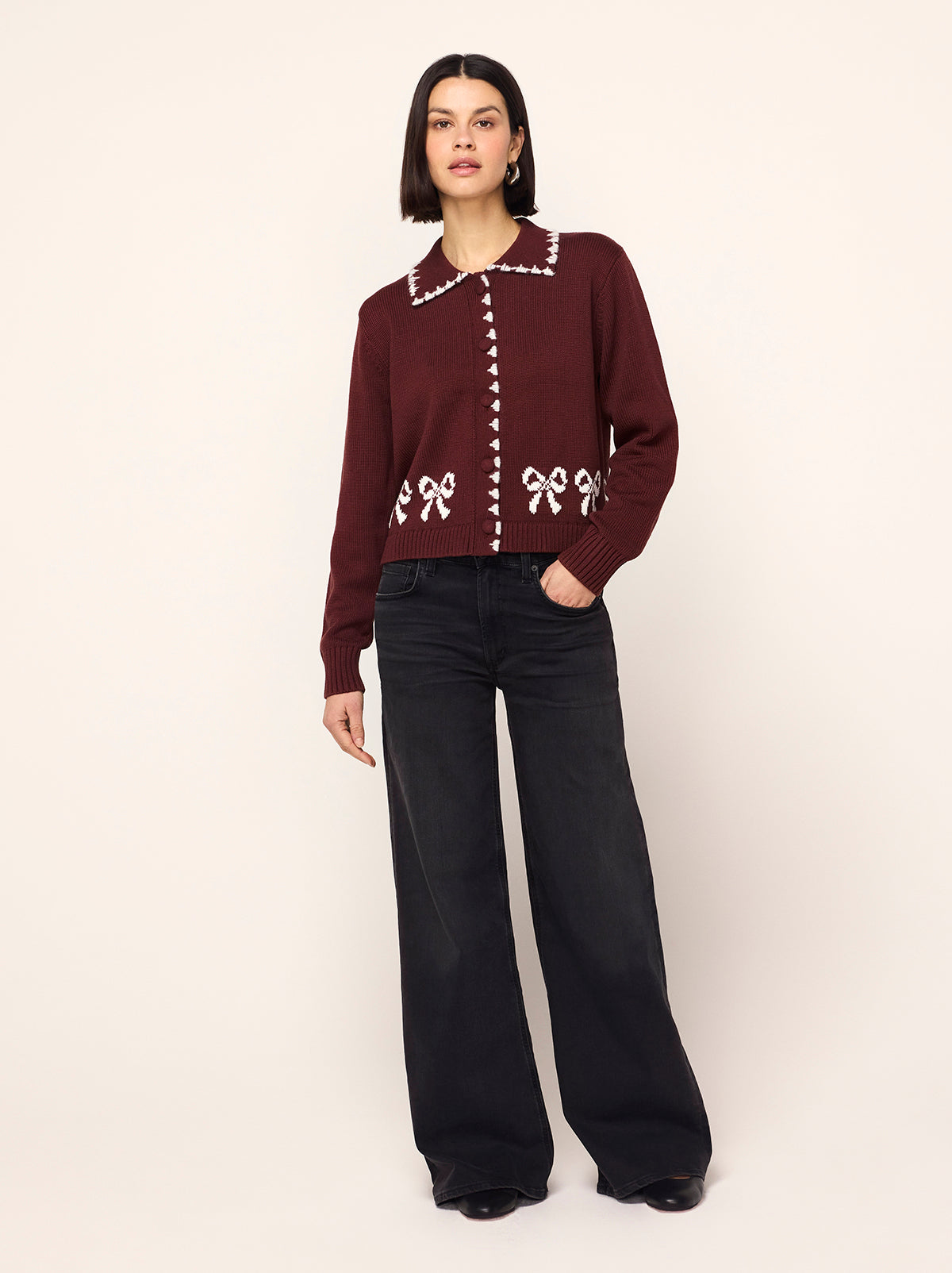 Polly Oxblood Bow Knit Cardigan - Polly is an oxblood cardigan with a contrasting ivory bow intarsia and crafted from a cosy cotton blend. Her ribbed sleeves and self-covered buttons make her a cut above the rest.